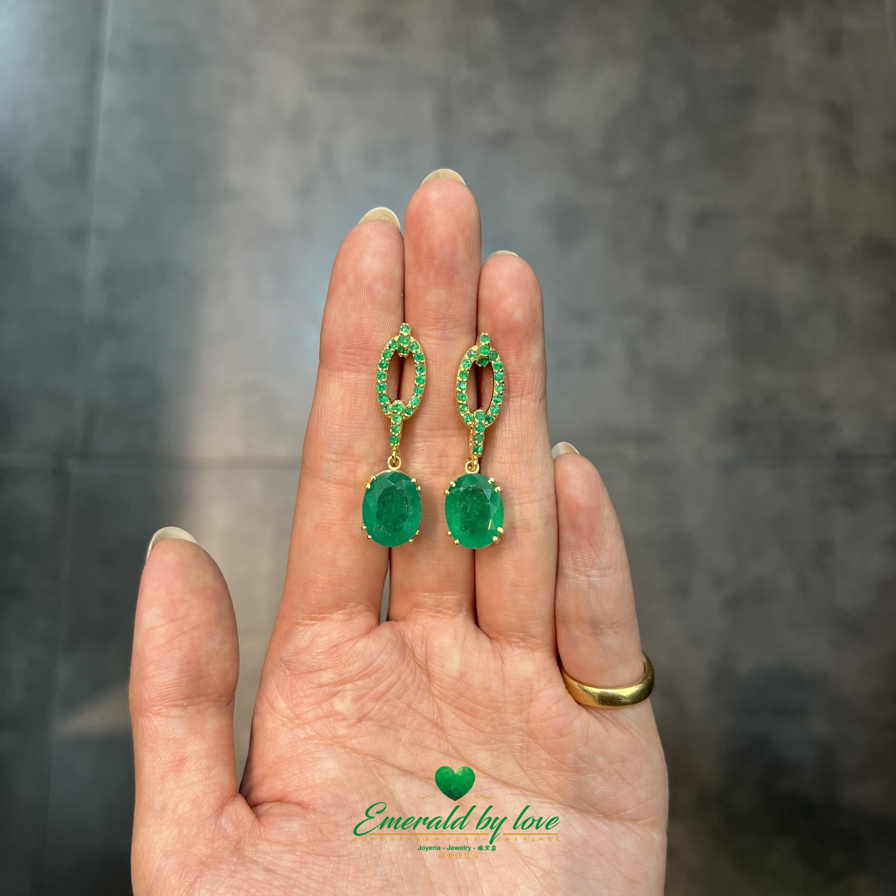 Boucles d'oreilles pendantes en or jaune avec de grandes émeraudes ovales et des accents d'émeraudes rondes