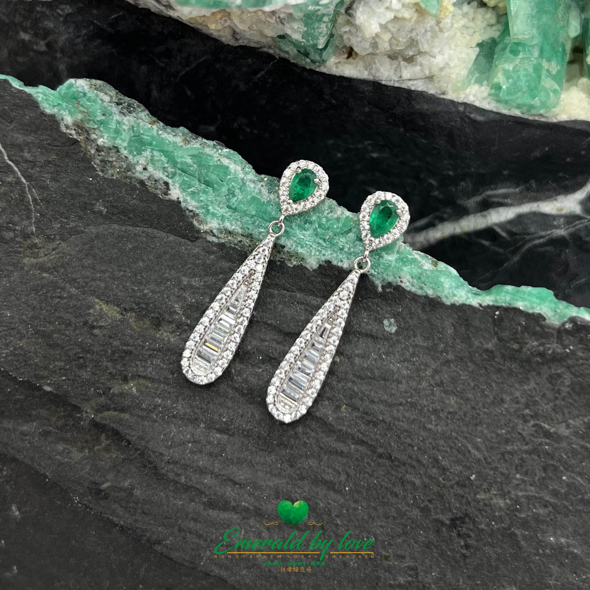Boucles d'oreilles pendantes allongées et élégantes avec de superbes émeraudes en forme de larme entourées