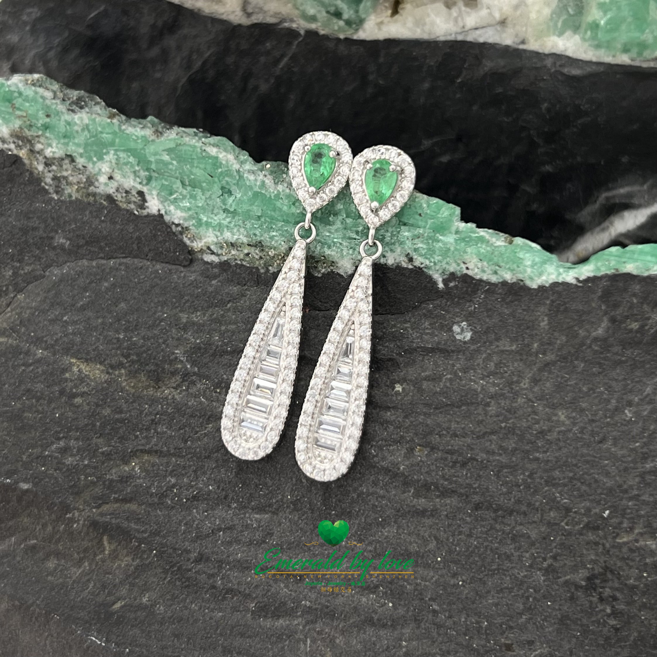 Boucles d'oreilles pendantes allongées et élégantes avec de superbes émeraudes en forme de larme entourées