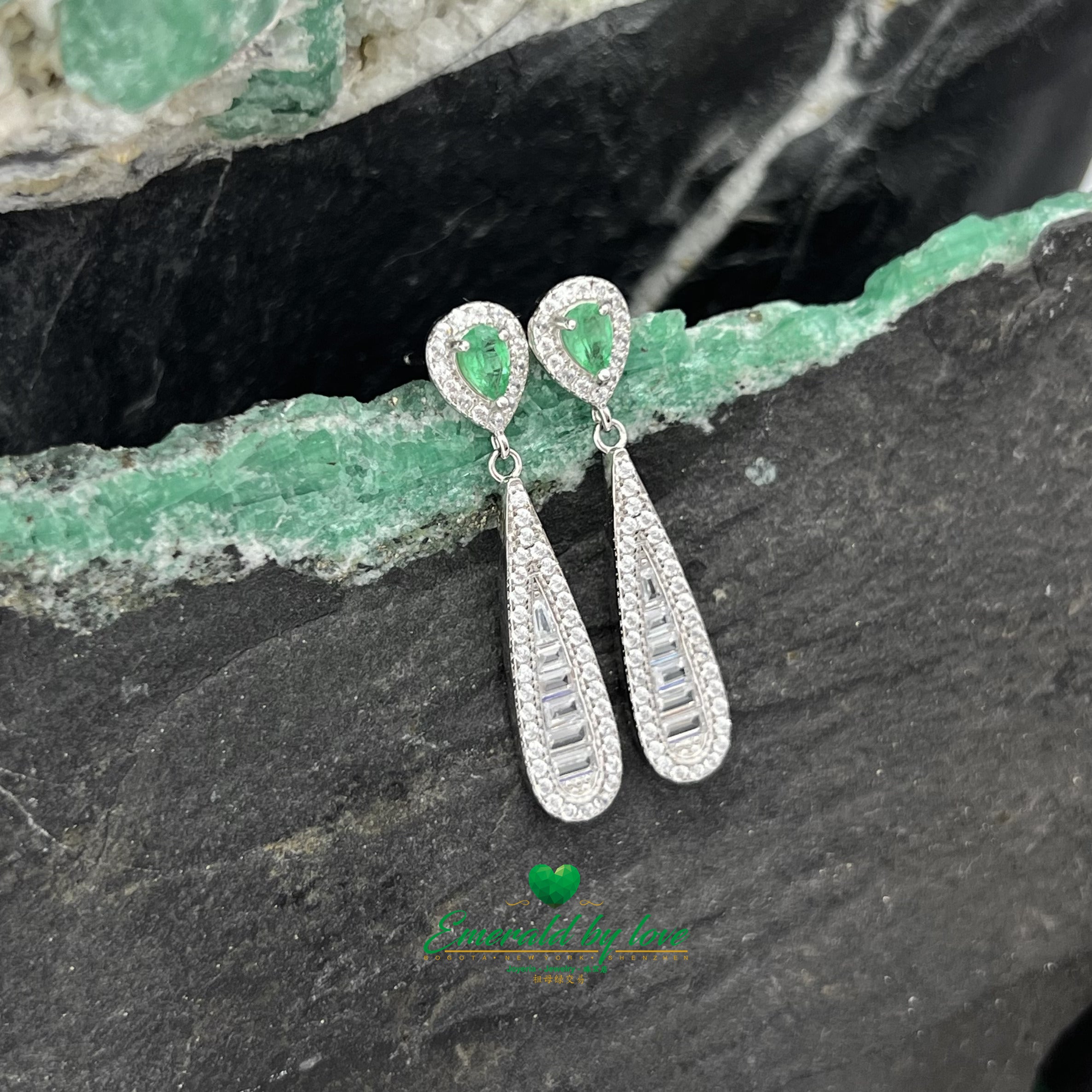 Boucles d'oreilles pendantes allongées et élégantes avec de superbes émeraudes en forme de larme entourées