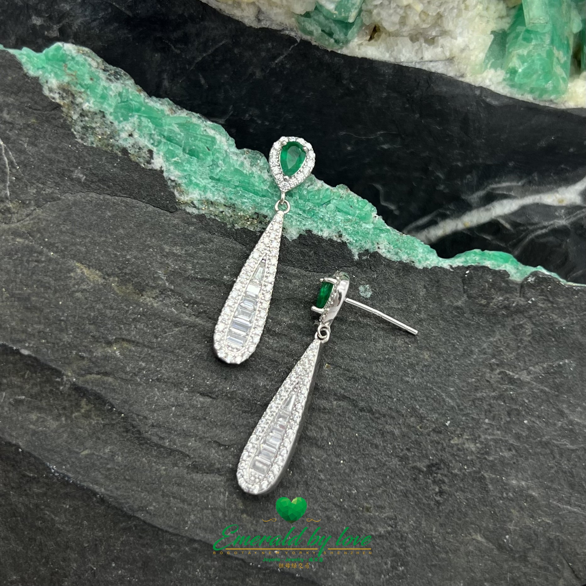 Boucles d'oreilles pendantes allongées et élégantes avec de superbes émeraudes en forme de larme entourées