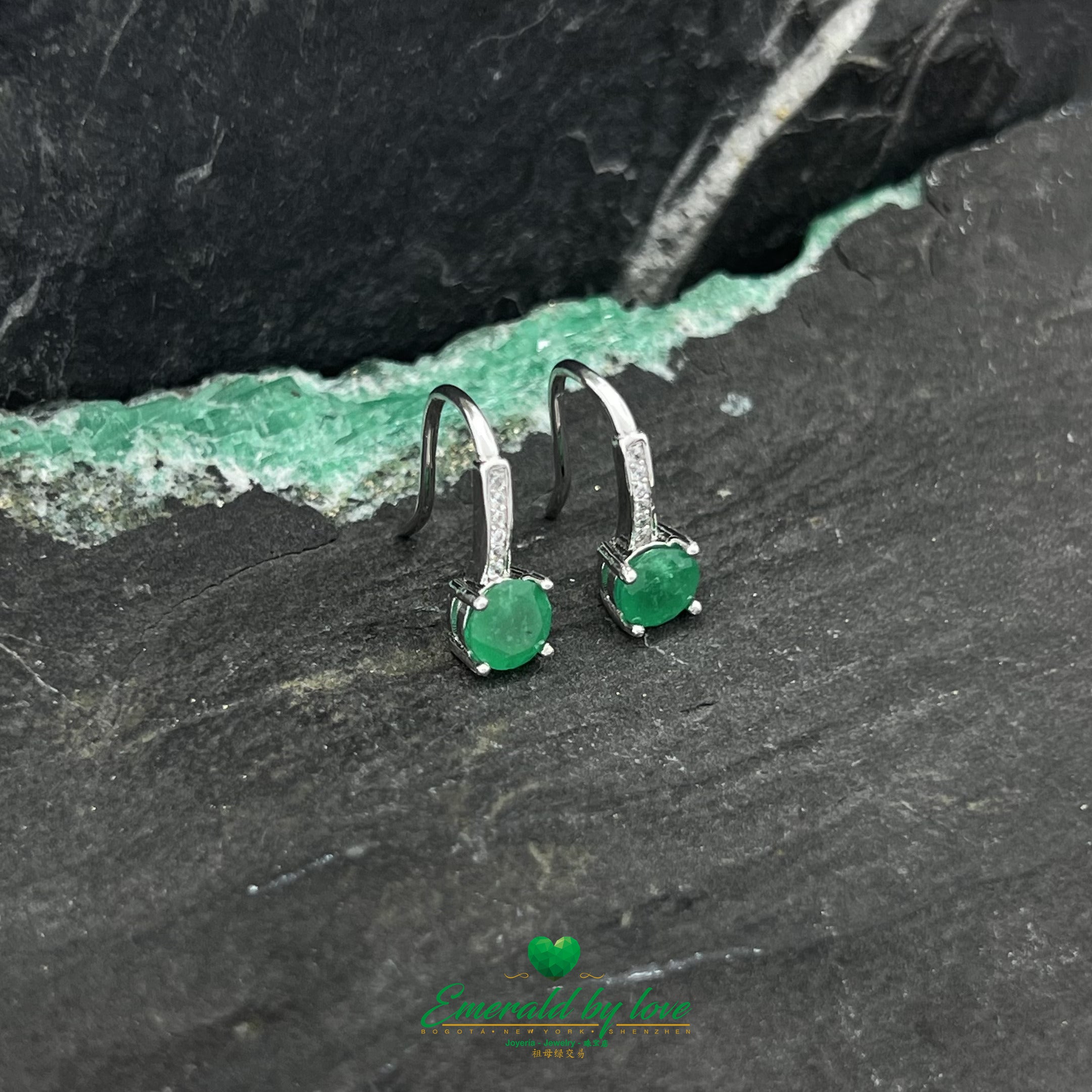Elegantes pendientes colgantes con detalle de esmeralda redonda