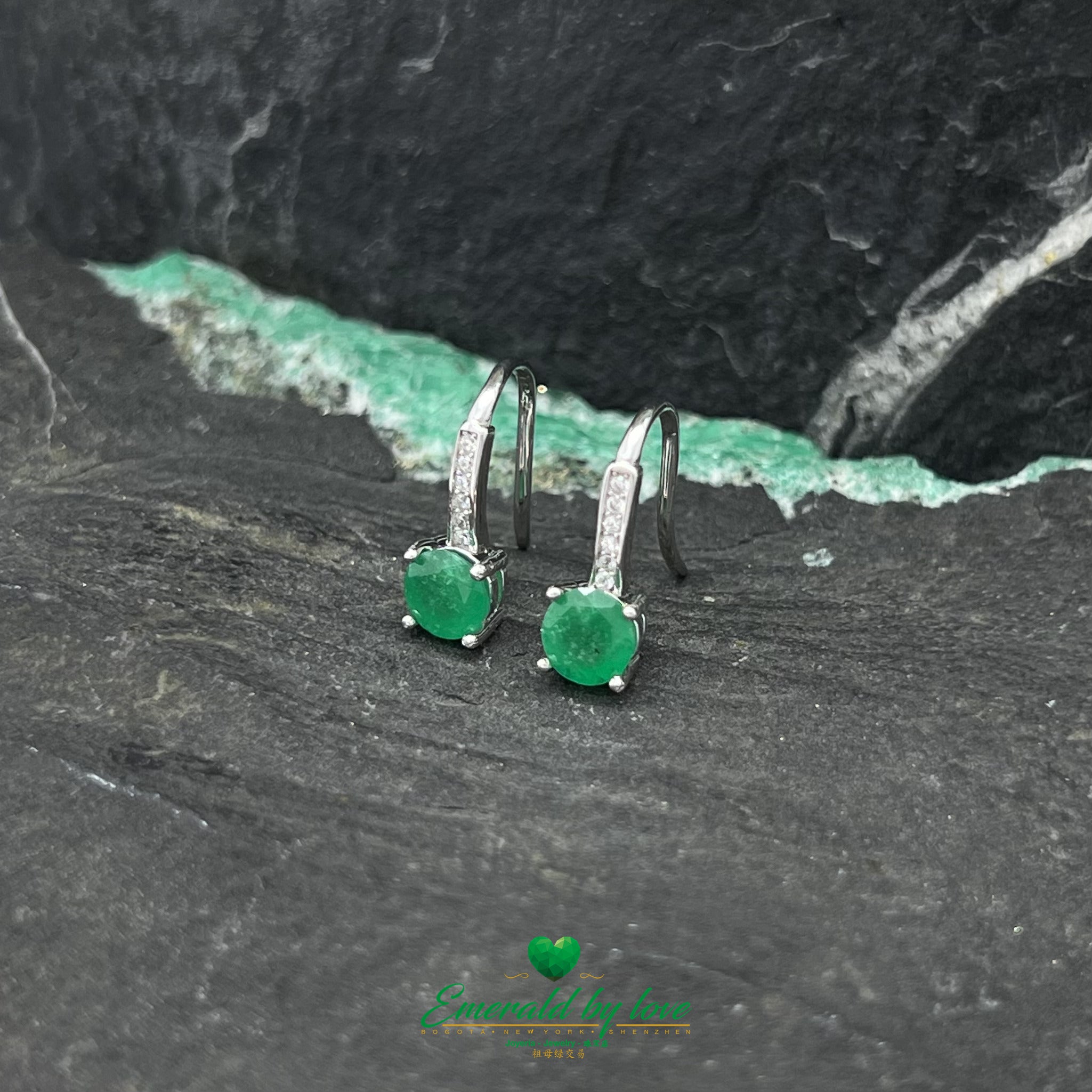 Elegantes pendientes colgantes con detalle de esmeralda redonda
