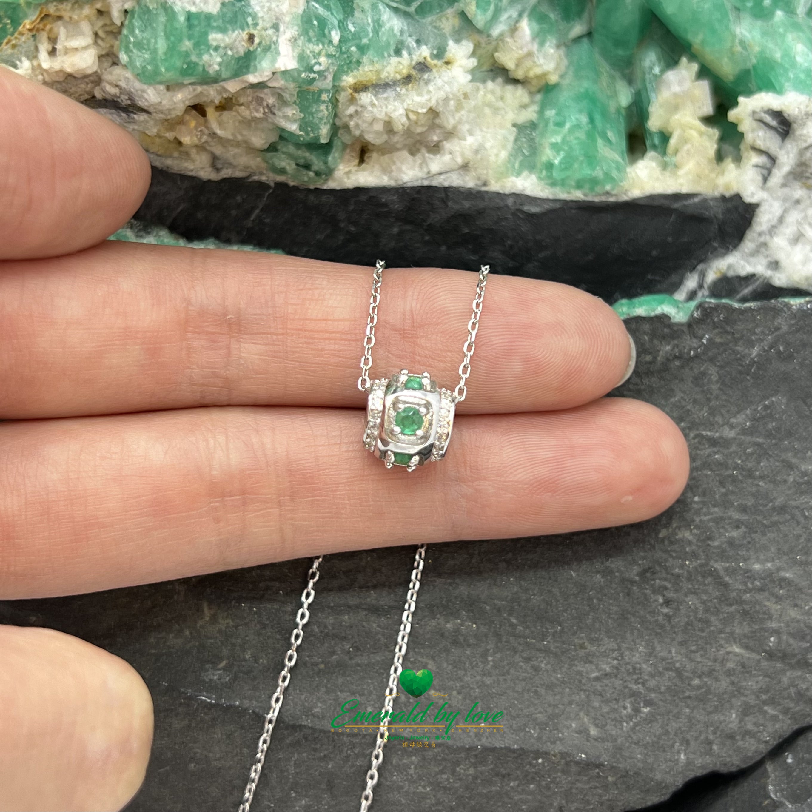 Colgante cilíndrico con esmeraldas redondas y circonitas en las esquinas