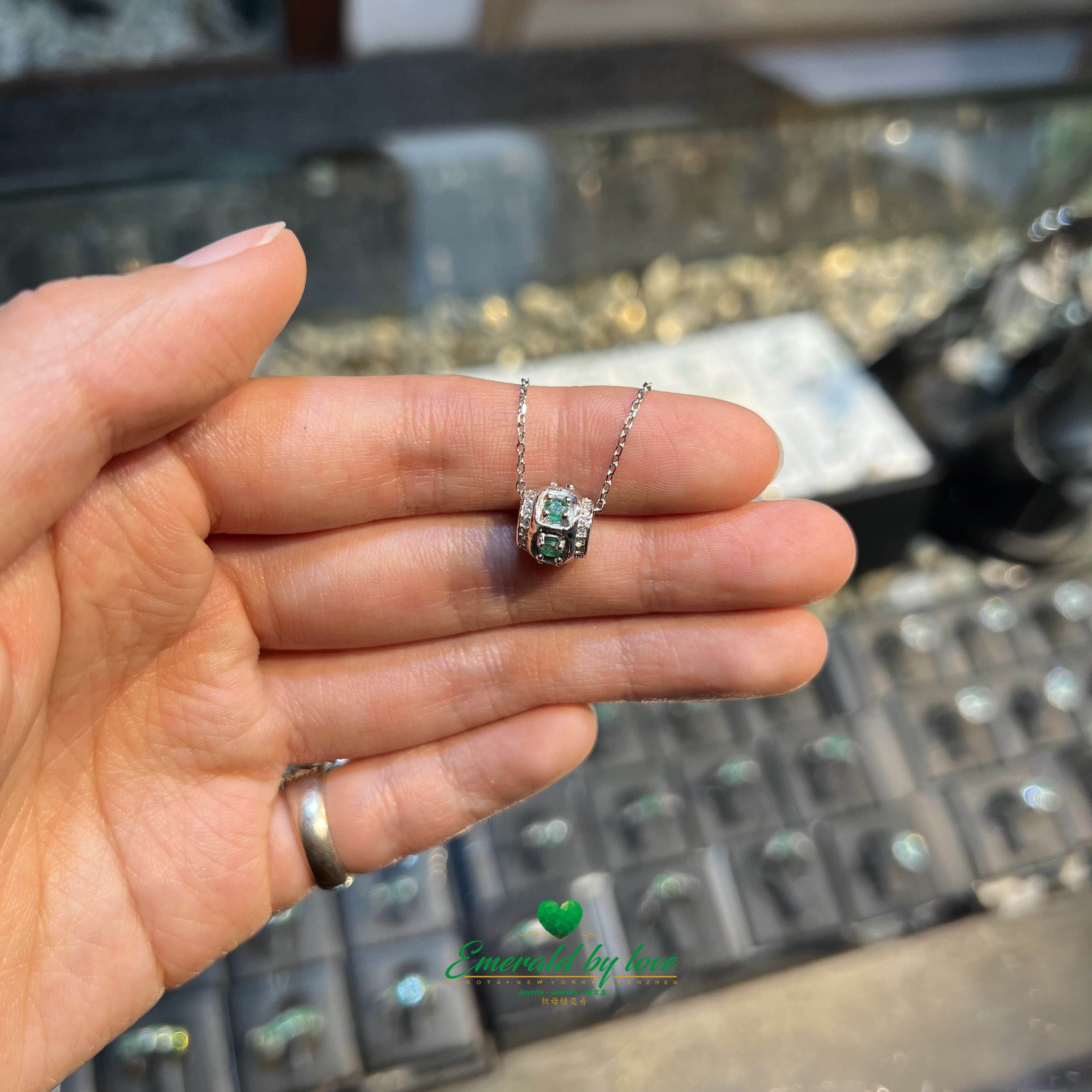 Colgante cilíndrico con esmeraldas redondas y circonitas en las esquinas
