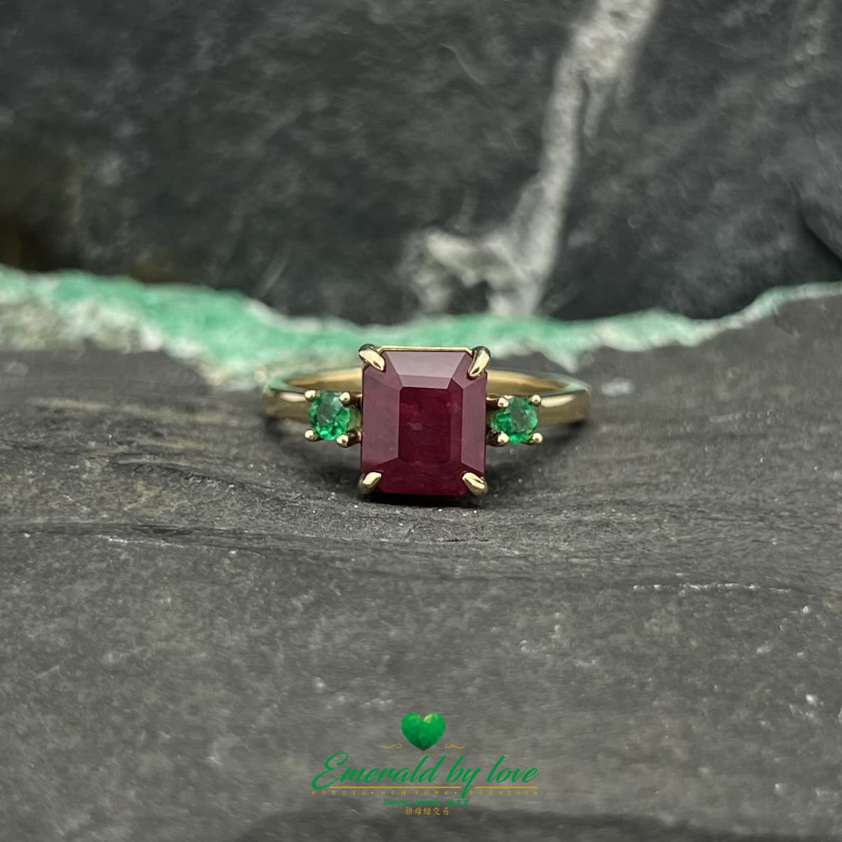 Royal Radiance : Bague en or jaune avec rubis central et émeraudes rondes flanquantes