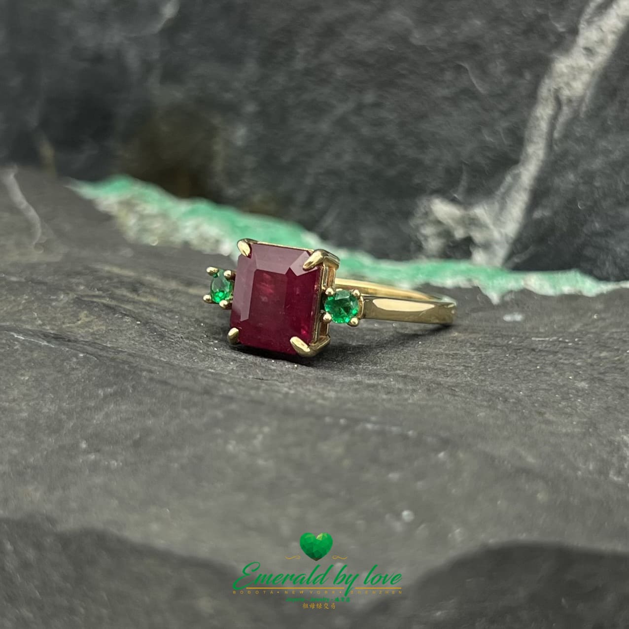 Royal Radiance : Bague en or jaune avec rubis central et émeraudes rondes flanquantes