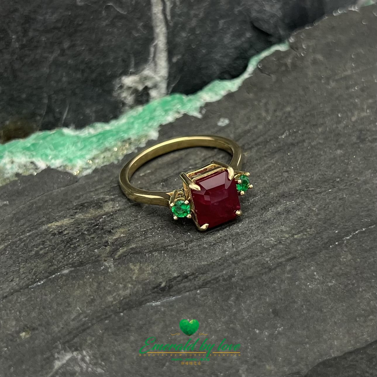 Royal Radiance : Bague en or jaune avec rubis central et émeraudes rondes flanquantes