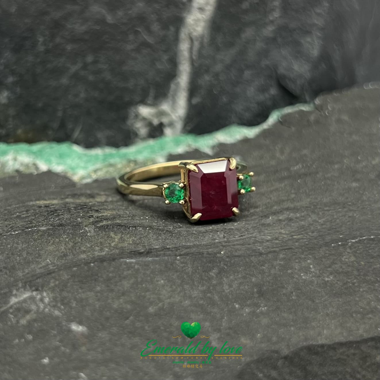 Royal Radiance : Bague en or jaune avec rubis central et émeraudes rondes flanquantes