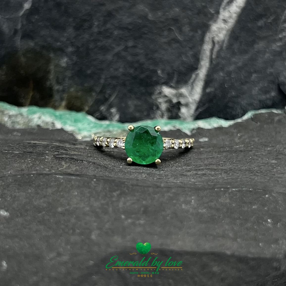 Encantamiento eterno: Anillo de oro amarillo con una vívida esmeralda redonda y una banda con incrustaciones de diamantes