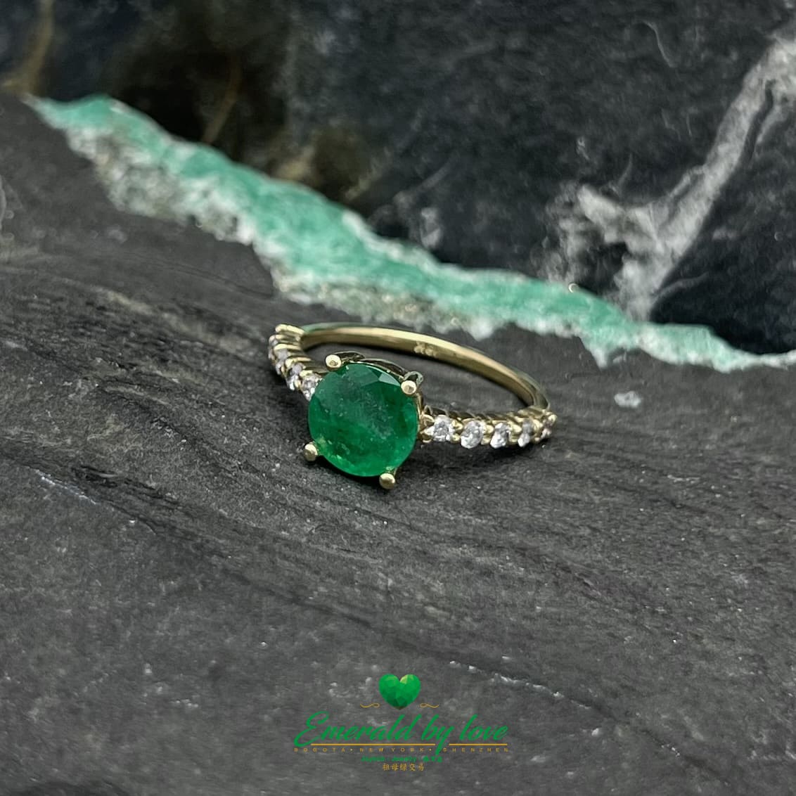Encantamiento eterno: Anillo de oro amarillo con una vívida esmeralda redonda y una banda con incrustaciones de diamantes