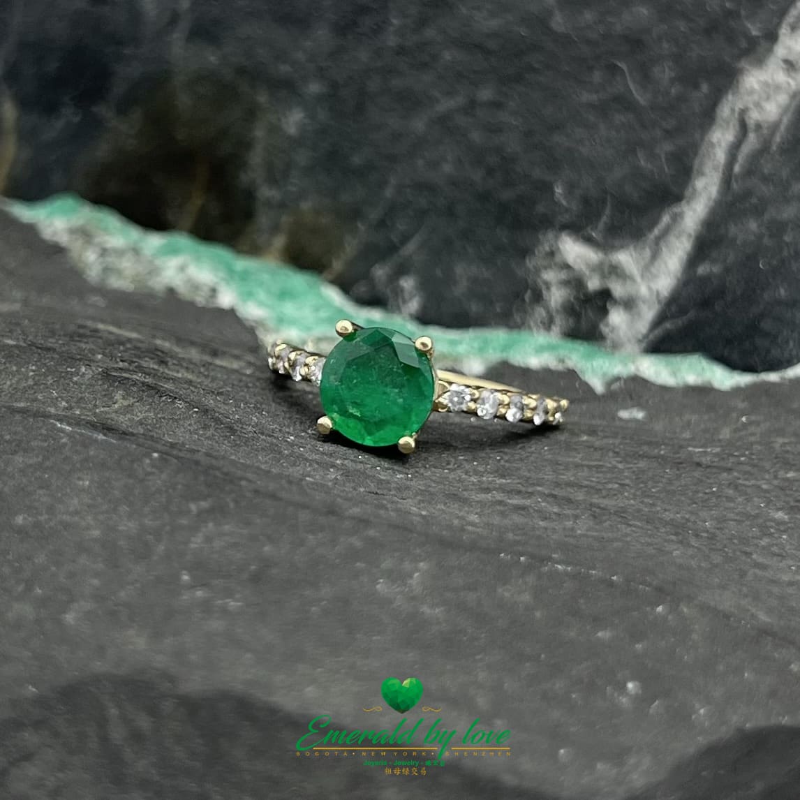 Encantamiento eterno: Anillo de oro amarillo con una vívida esmeralda redonda y una banda con incrustaciones de diamantes