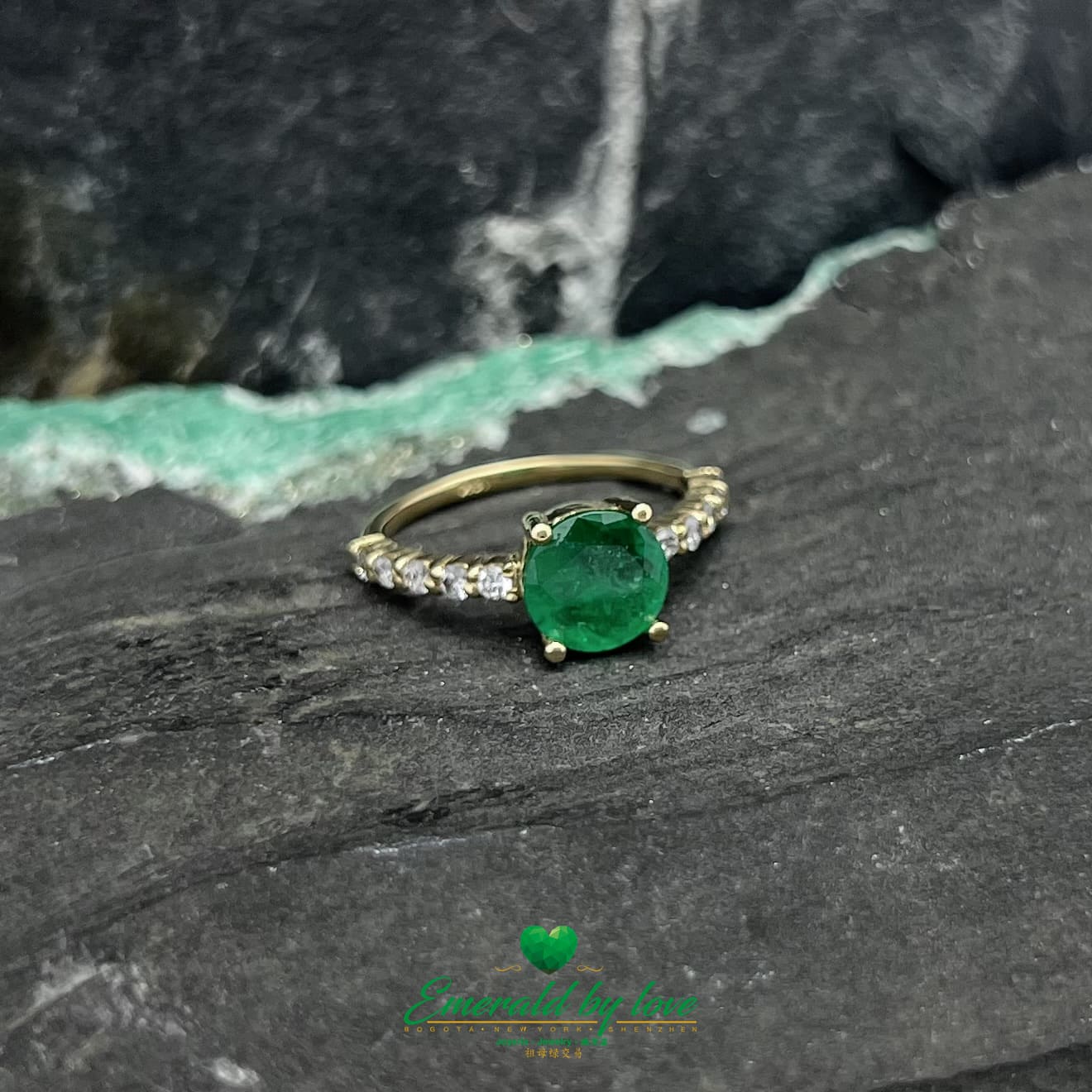 Encantamiento eterno: Anillo de oro amarillo con una vívida esmeralda redonda y una banda con incrustaciones de diamantes