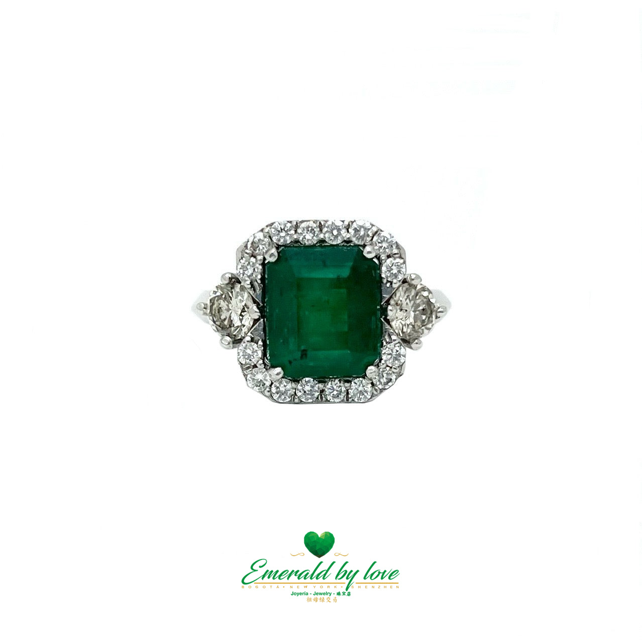 White Gold Ring with Emerald Cut Emerald Center, Flanked by Two Medium Diamonds, and Surrounded by Small Diamonds