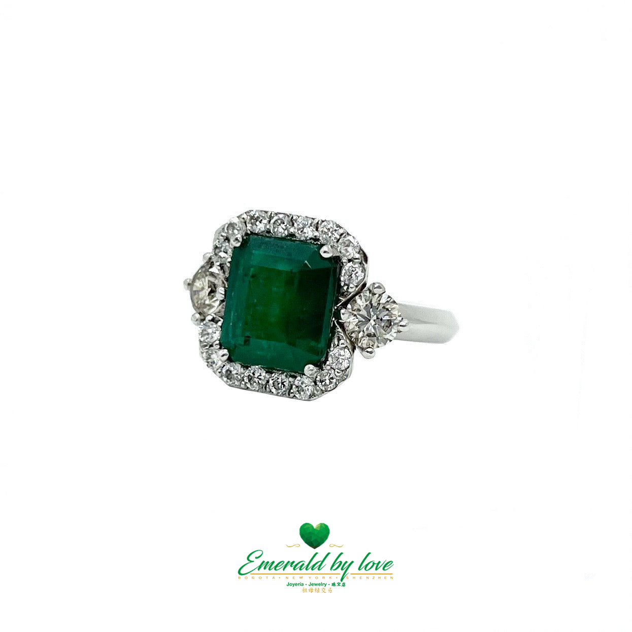 White Gold Ring with Emerald Cut Emerald Center, Flanked by Two Medium Diamonds, and Surrounded by Small Diamonds