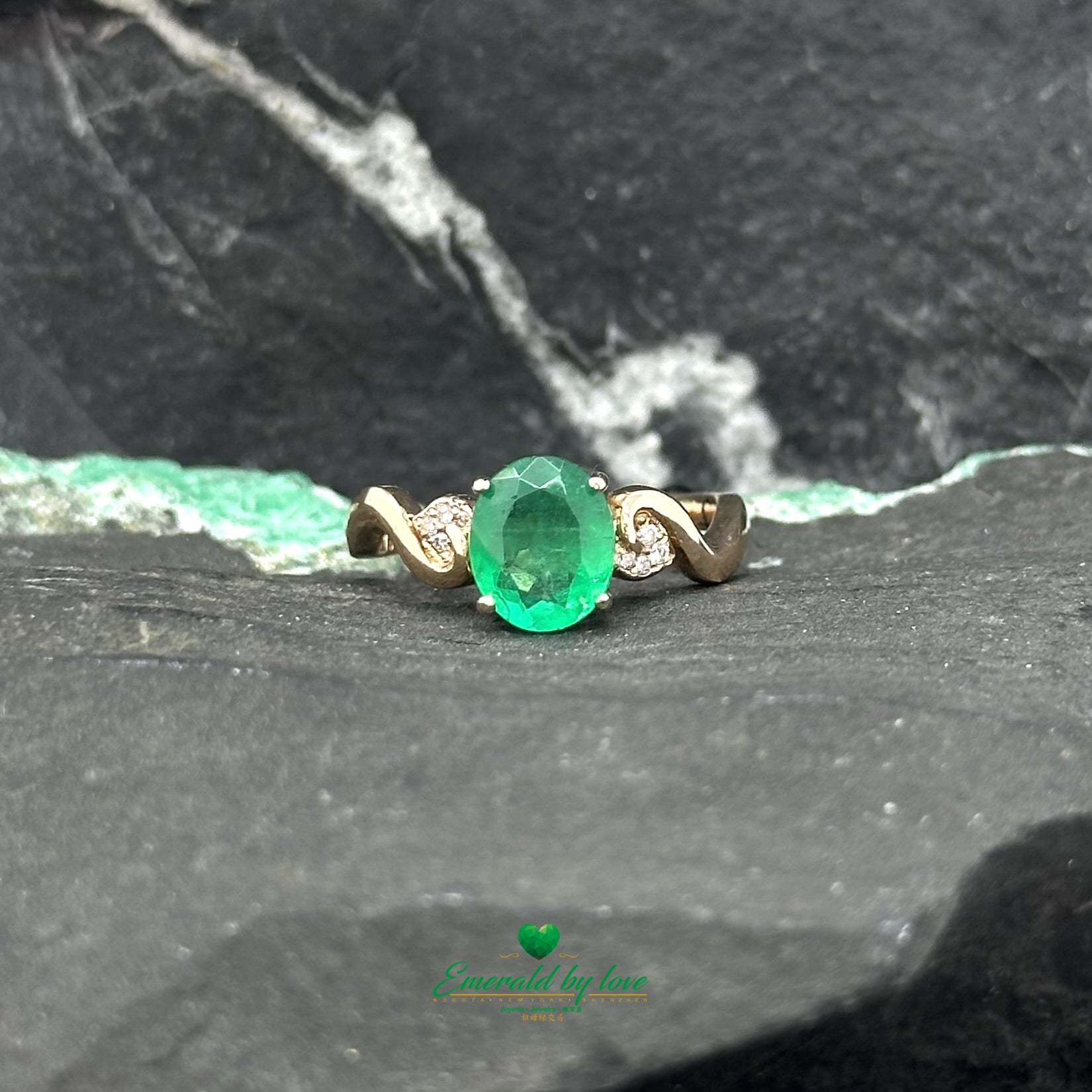 Bague détaillée en or rose avec émeraude ovale centrale et filigrane accentué de diamants