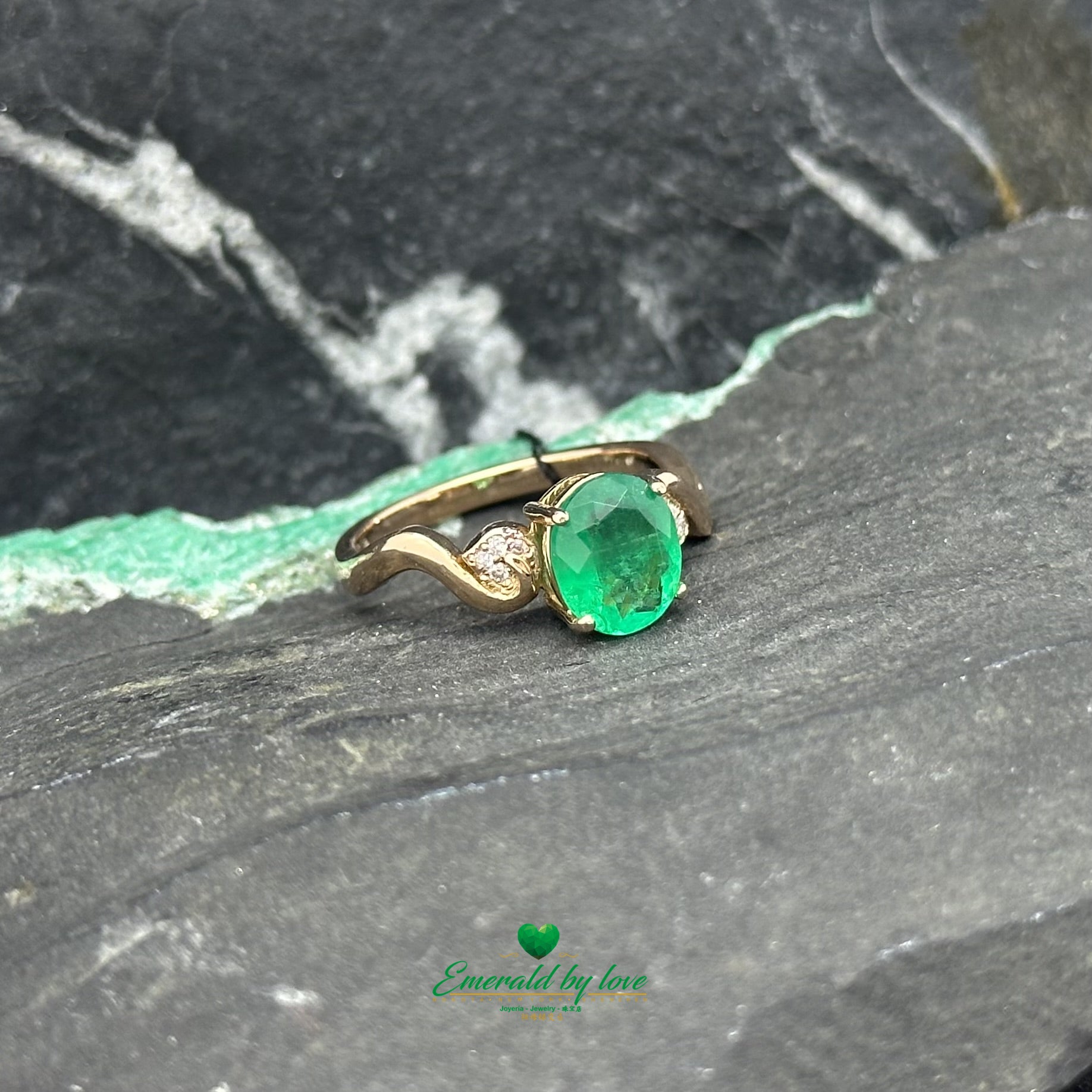 Bague détaillée en or rose avec émeraude ovale centrale et filigrane accentué de diamants
