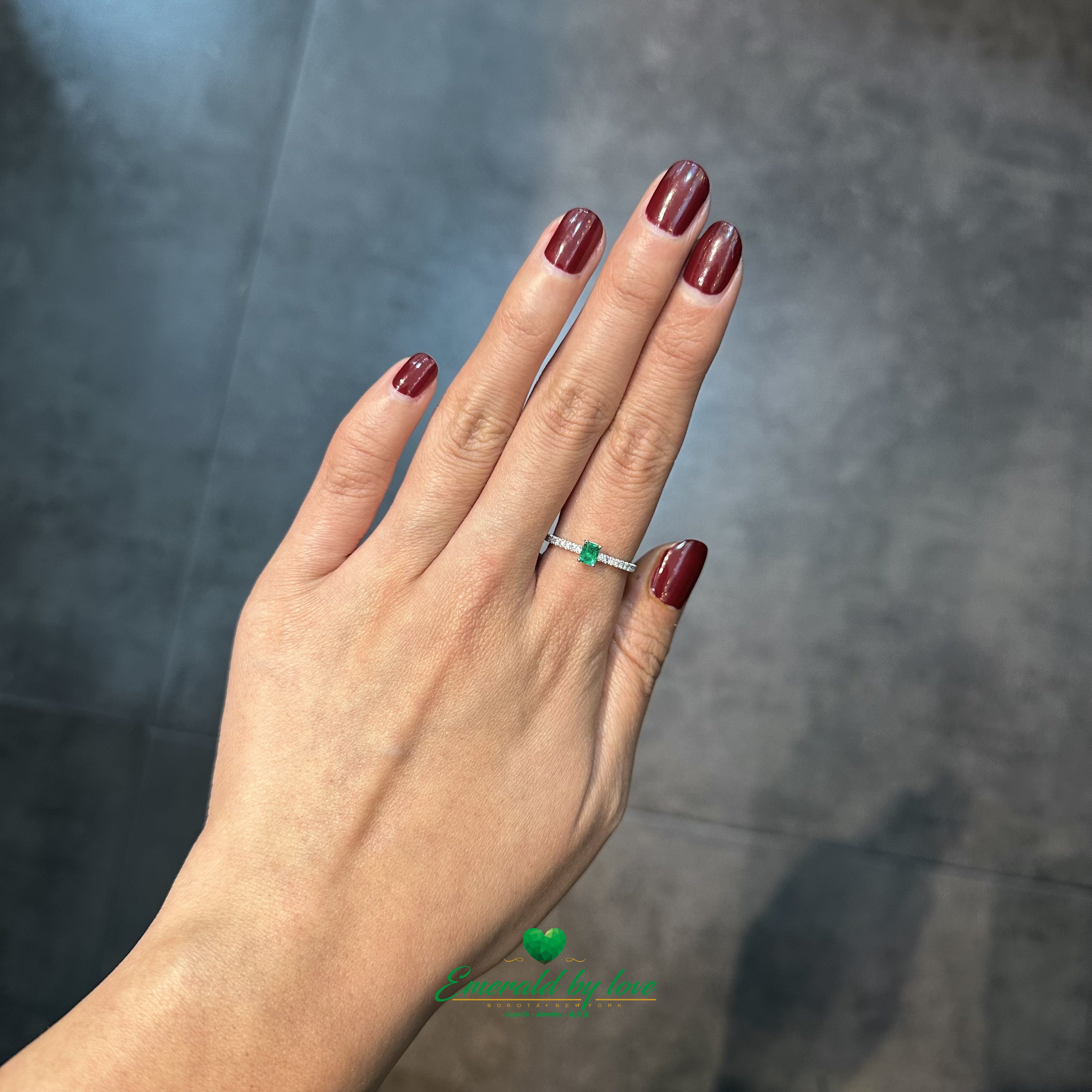 Elegant round-cut Colombian emerald engagement ring featuring a seamless invisible shank design