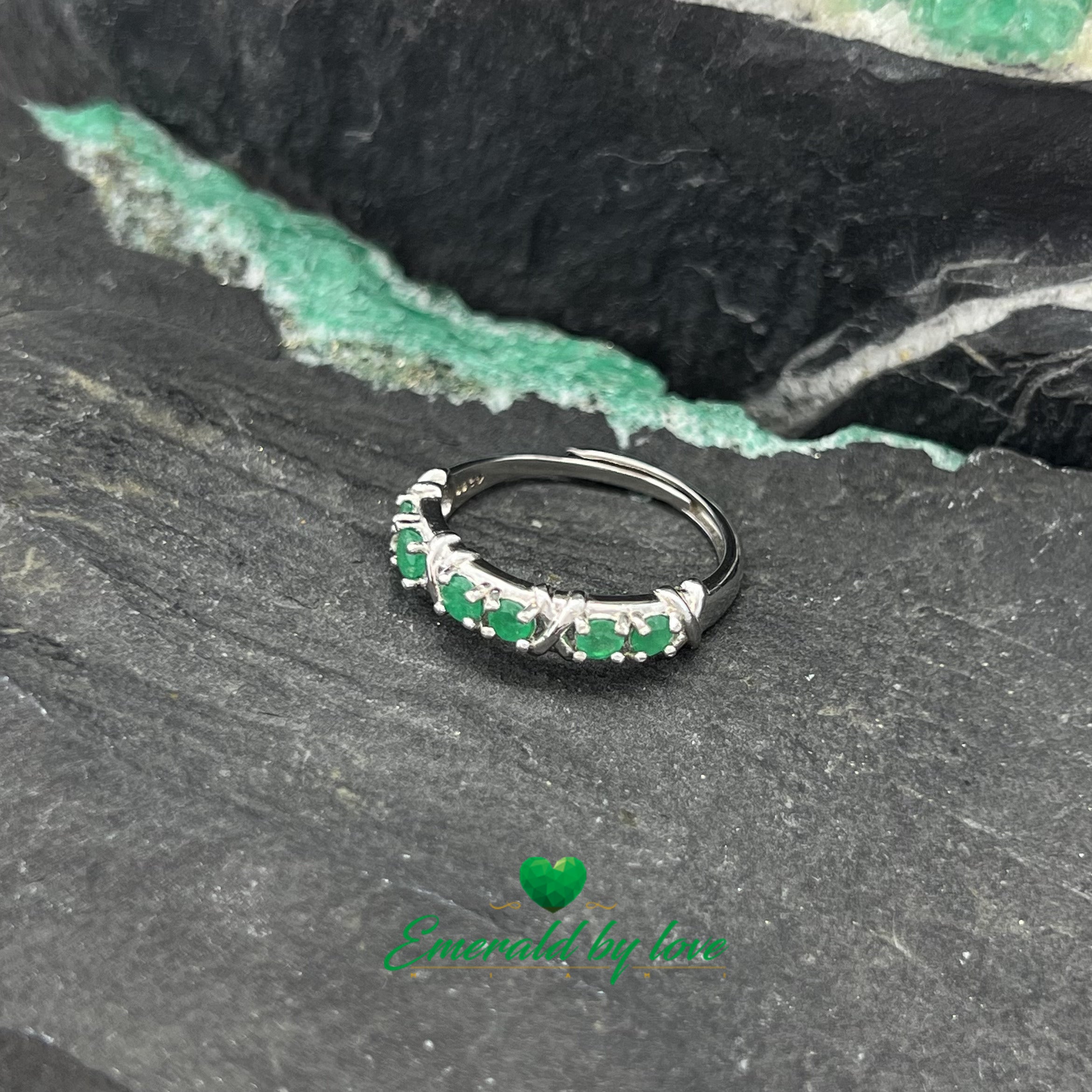 Elegante anillo de banda con seis esmeraldas redondas en pares