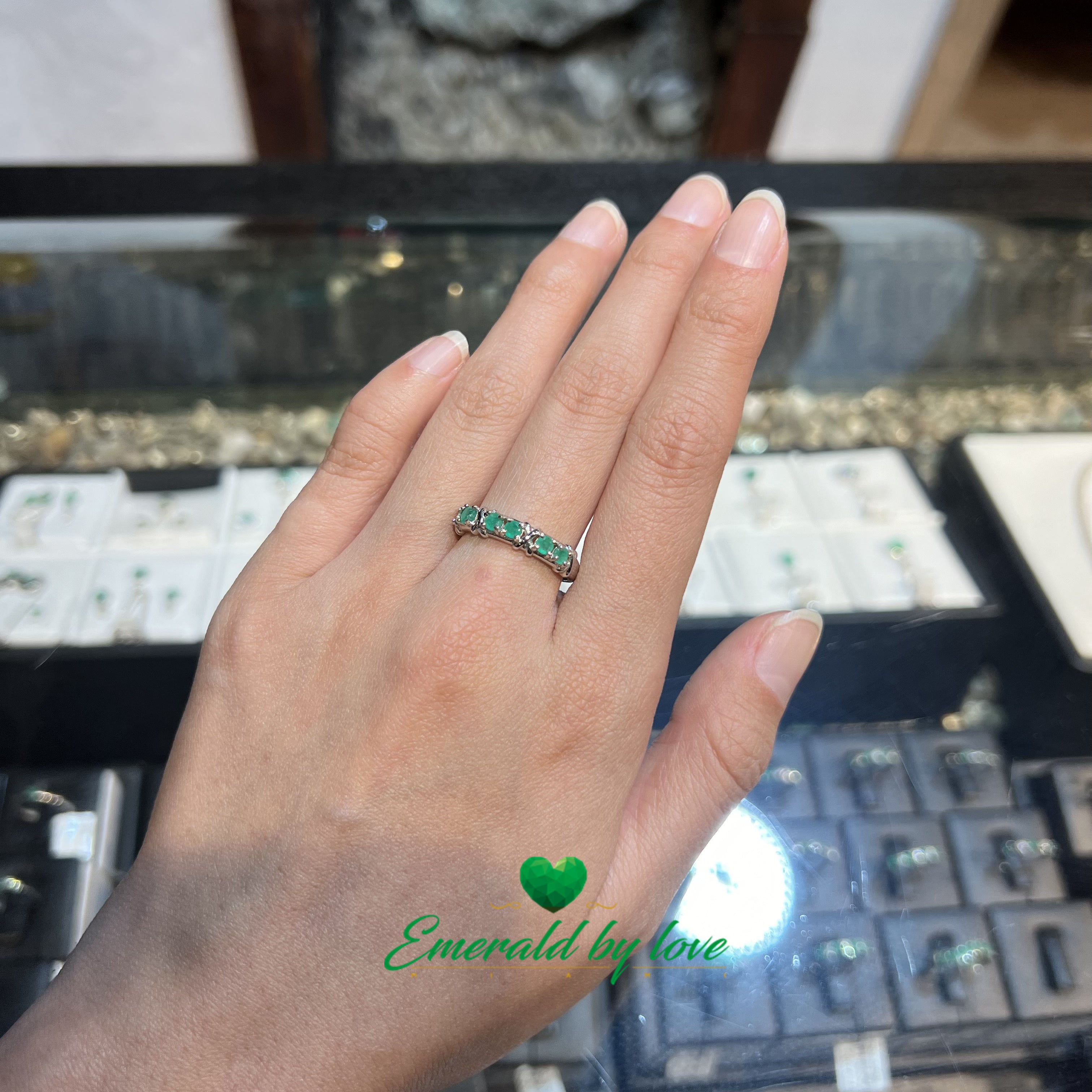 Elegante anillo de banda con seis esmeraldas redondas en pares