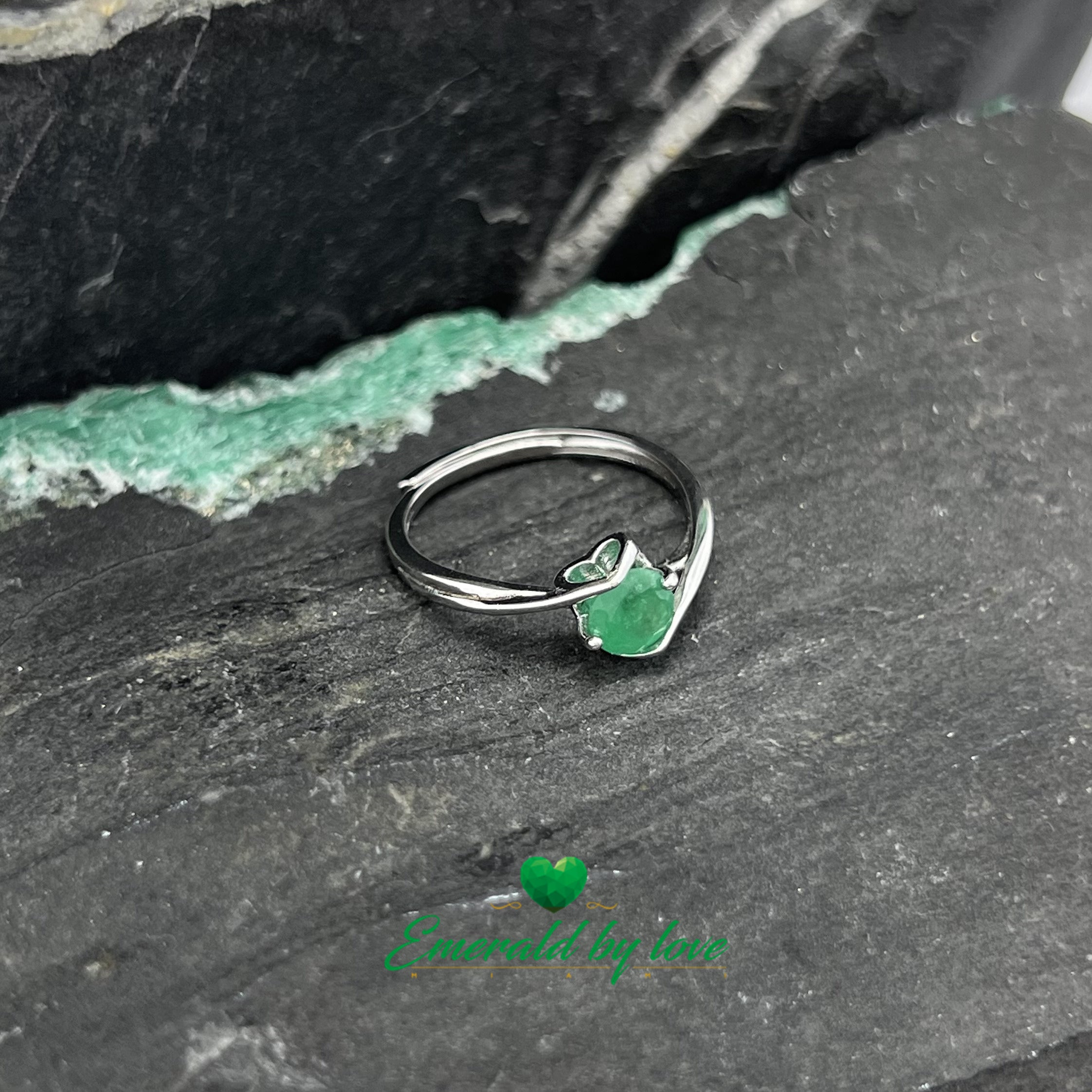 Bague solitaire avec émeraude ronde centrale et griffes décorées de cœurs
