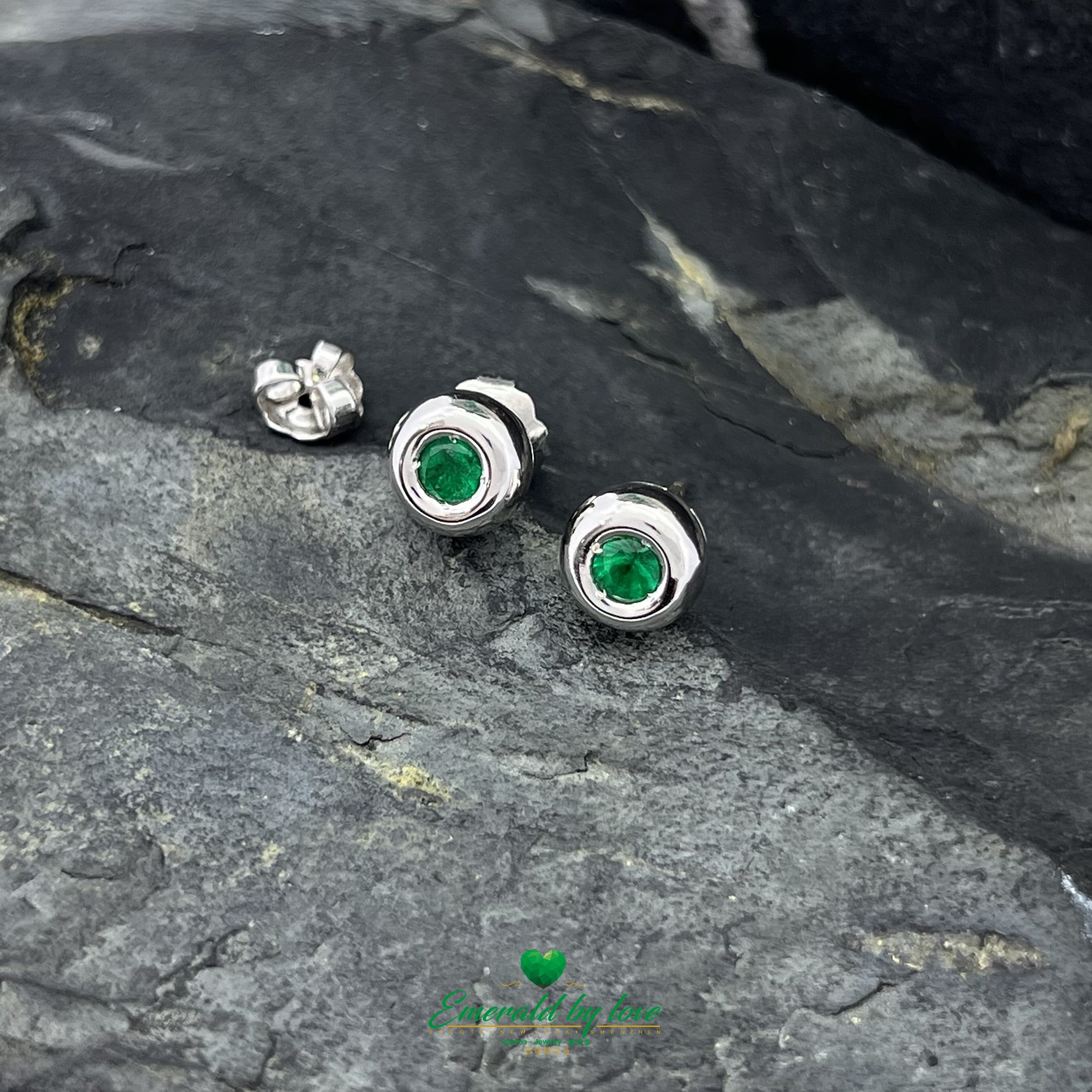 Conjunto de joyas de oro blanco con pendientes redondos y colgante con esmeralda central