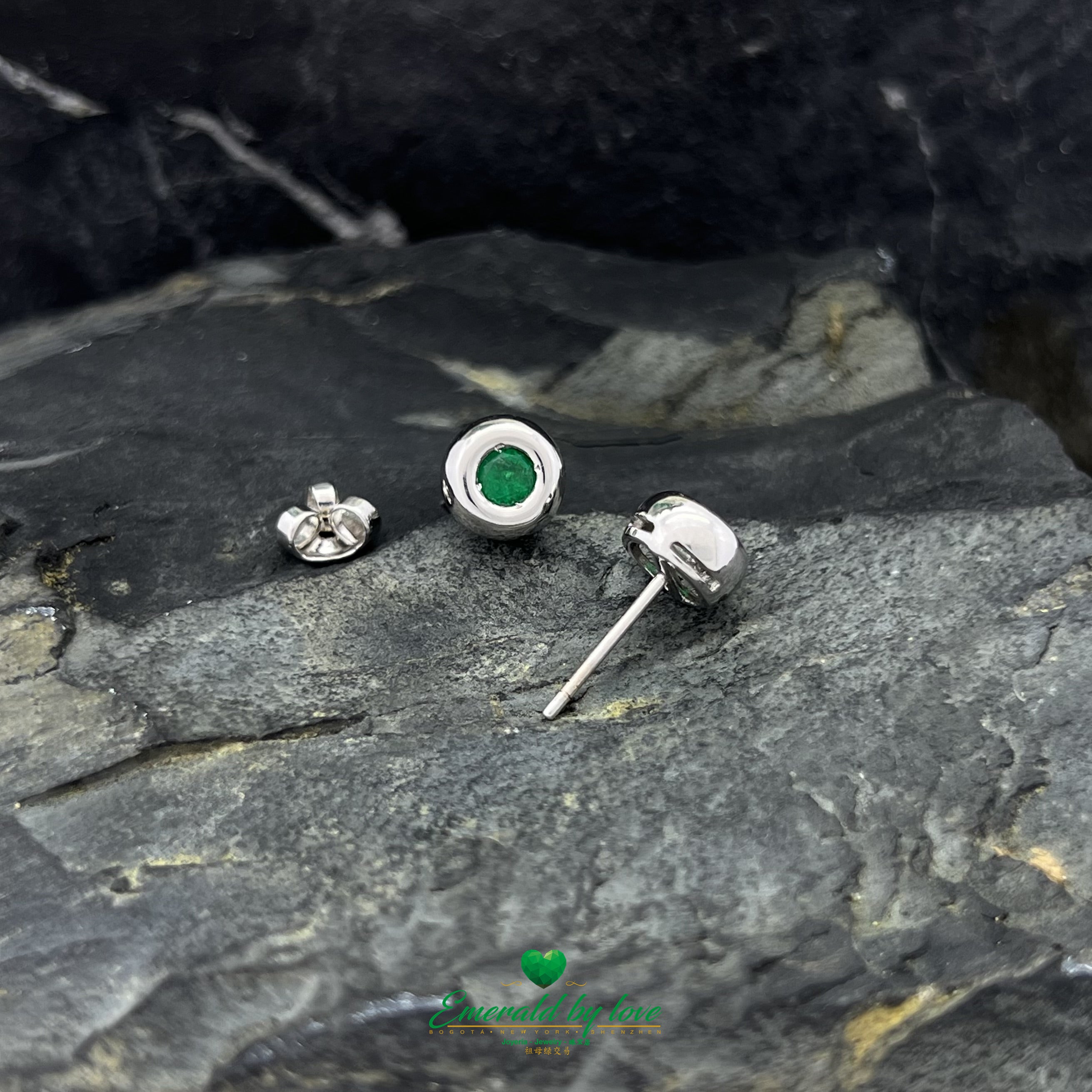 Conjunto de joyas de oro blanco con pendientes redondos y colgante con esmeralda central