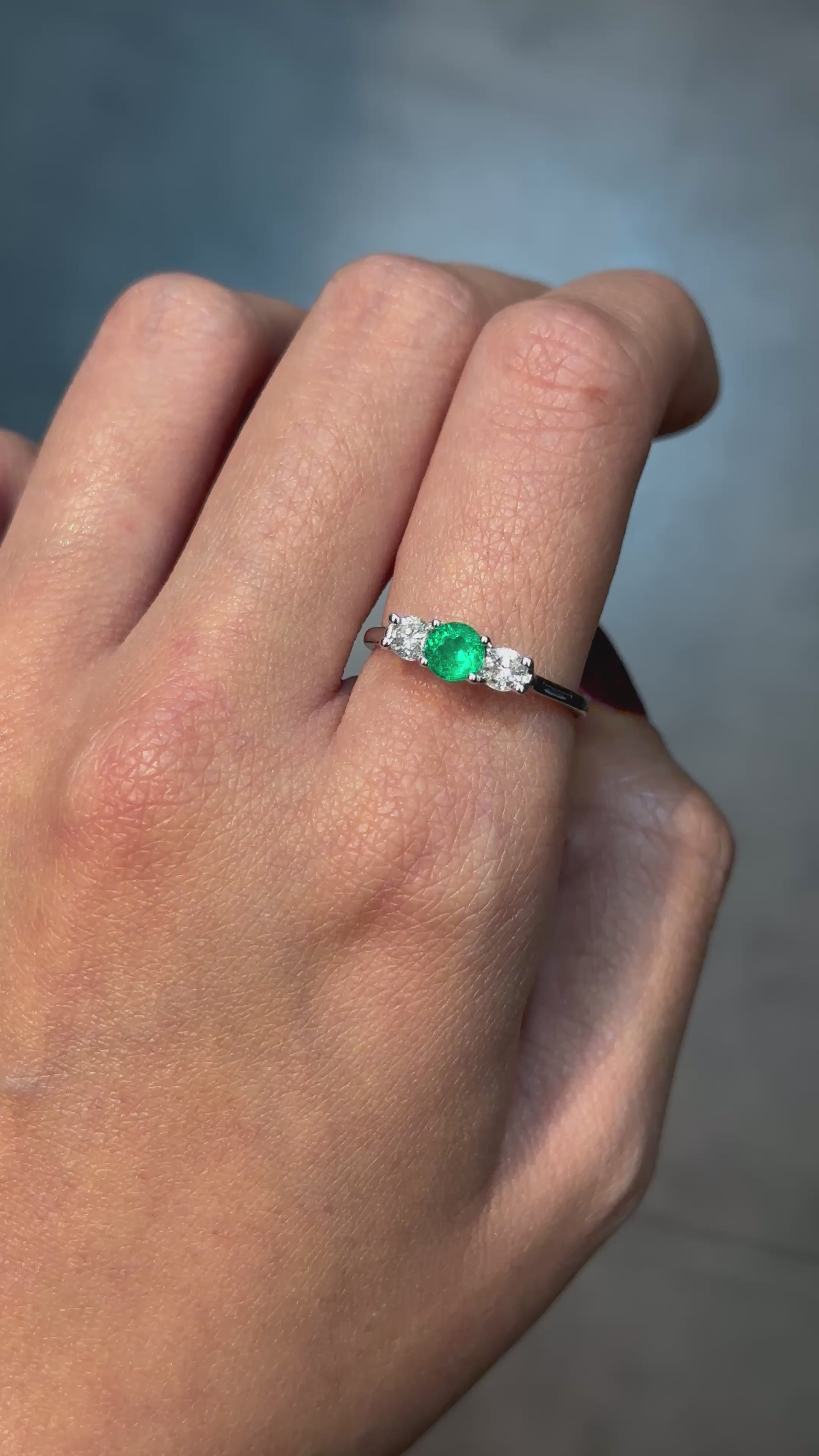 classic ring highlights a deep green emerald and diamonds.