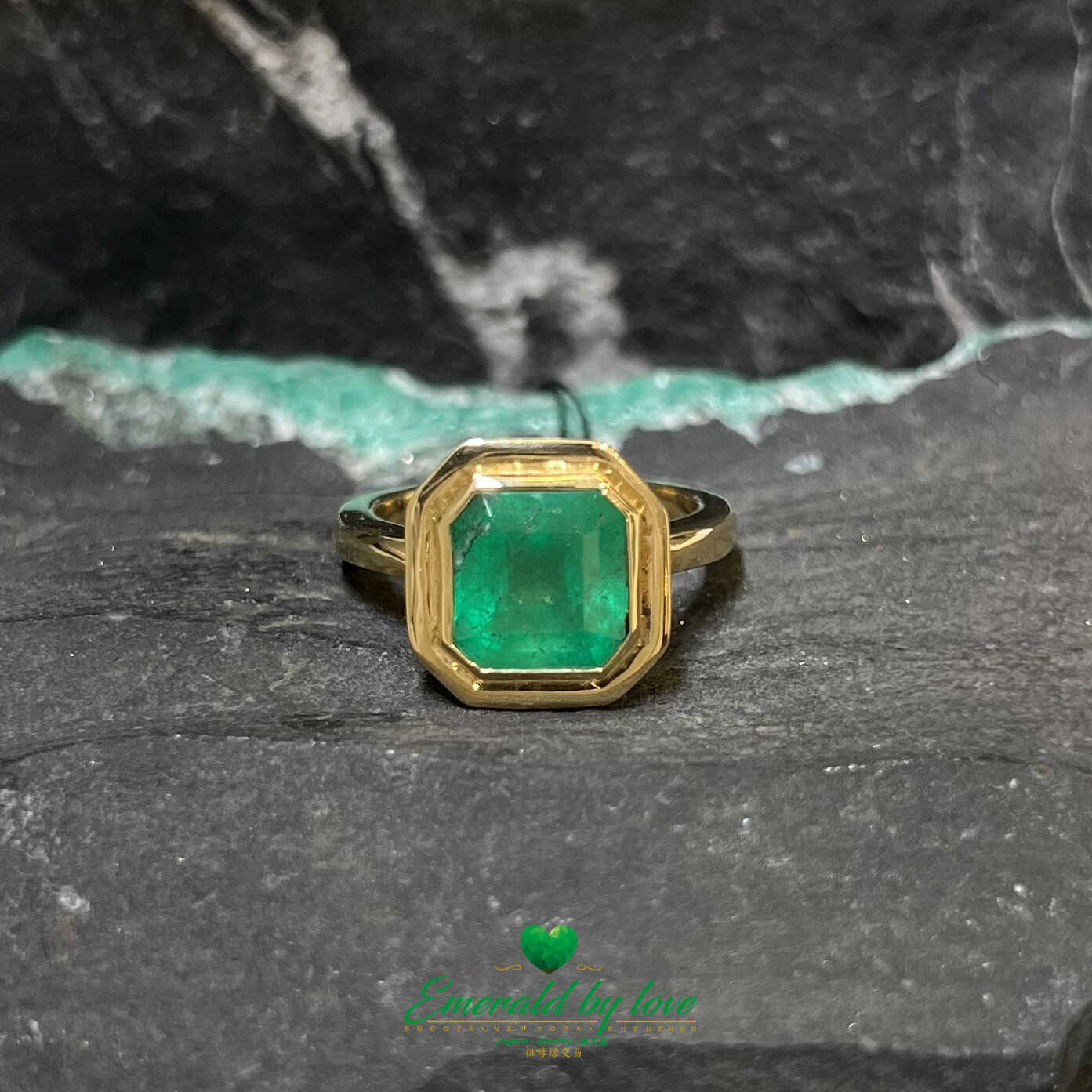Atrevido anillo de oro amarillo con esmeralda de talla cuadrada en engaste de bisel