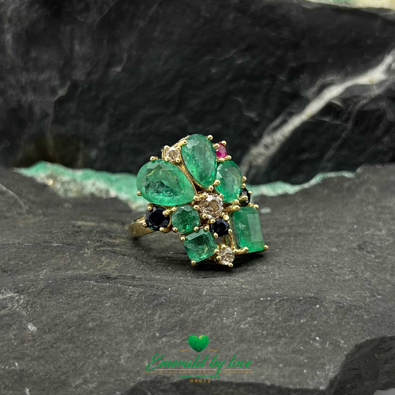 Anillo de oro amarillo adornado con esmeraldas de cristal, diamantes, zafiros y rubíes