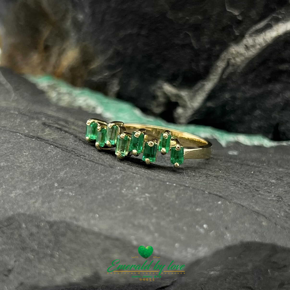 Hermoso anillo de oro amarillo con esmeraldas baguette de diseño uniforme