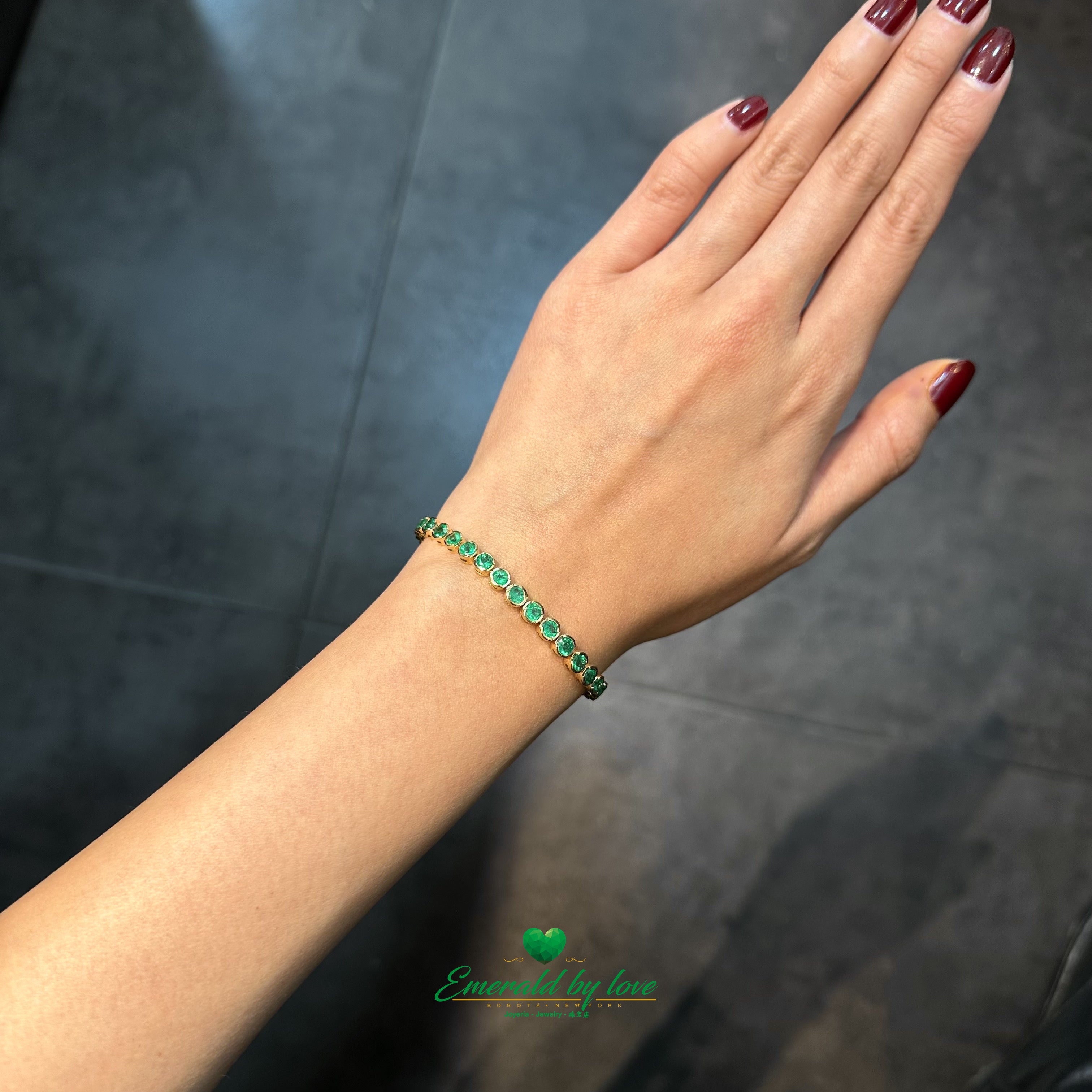 Side view of slim gold bracelet with natural emeralds