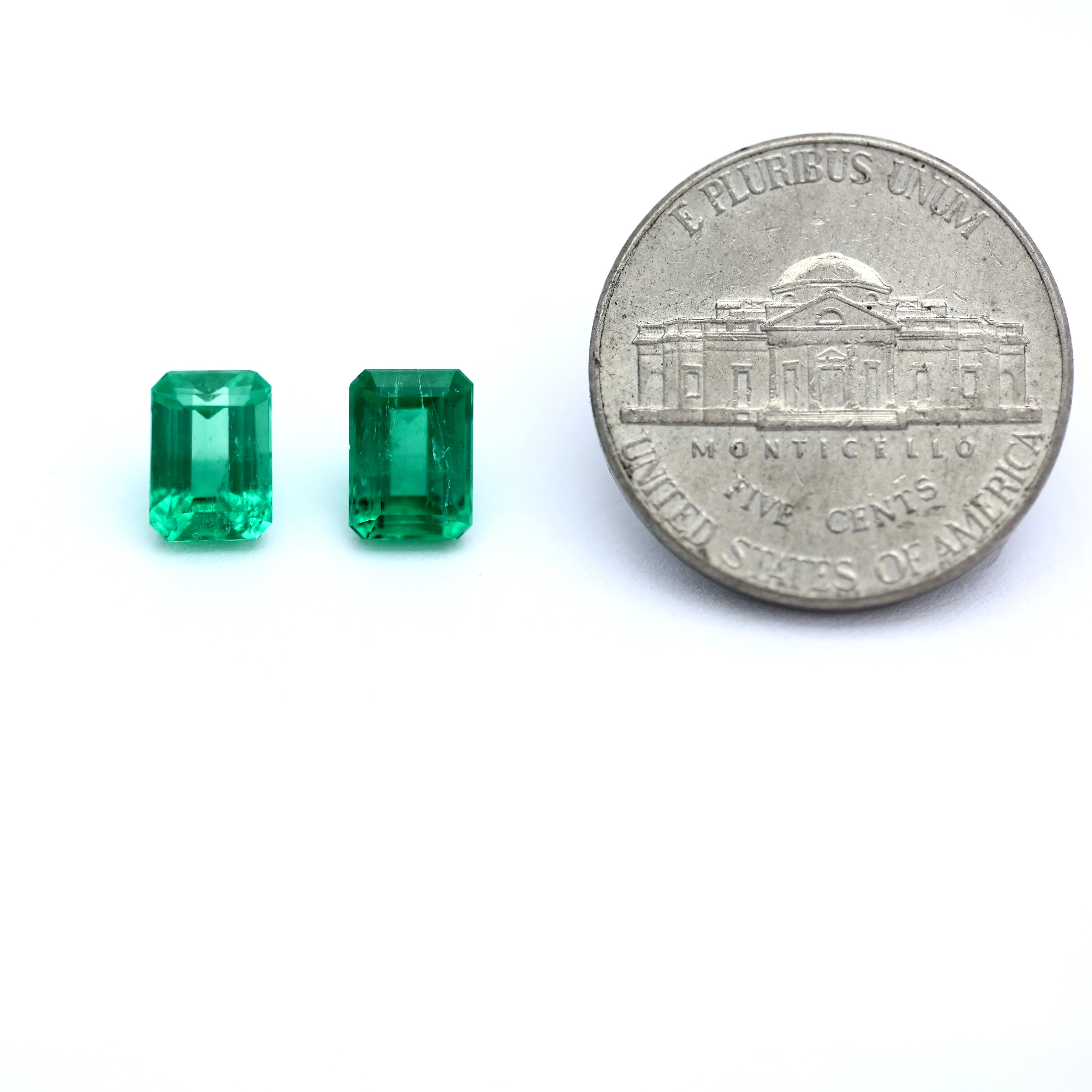 Coin comparison size of pair of emeralds 