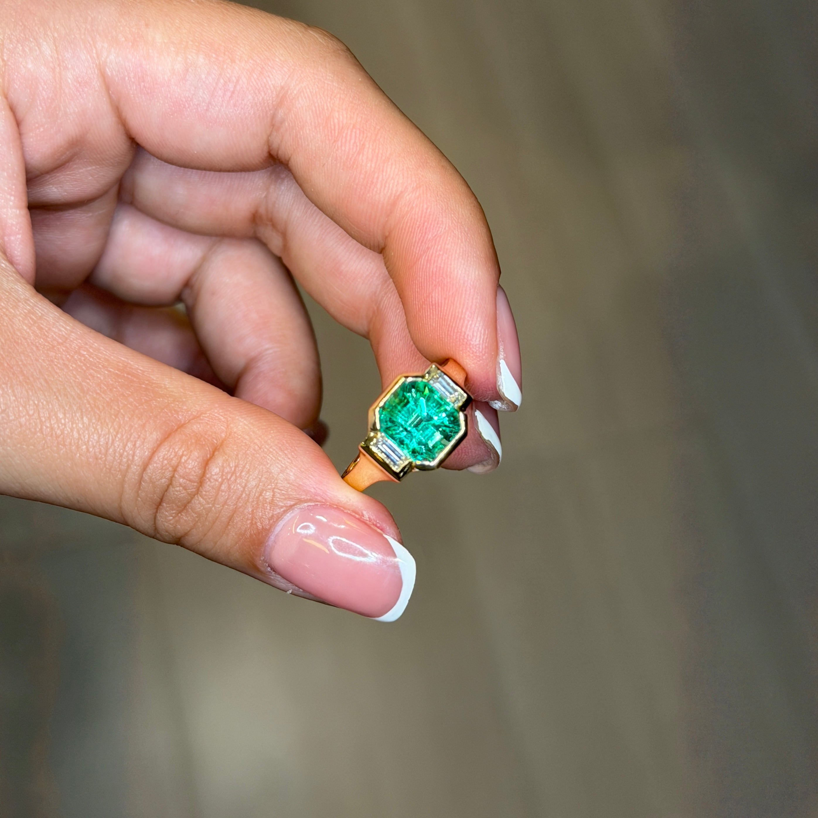 Elegant Colombian Emerald Bezel Ring in Yellow Gold with Diamond Baguette Side Stones