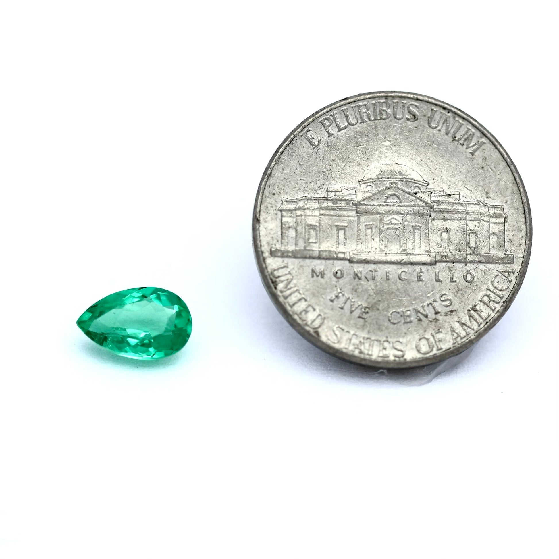 comparison size coin with colombian emerald