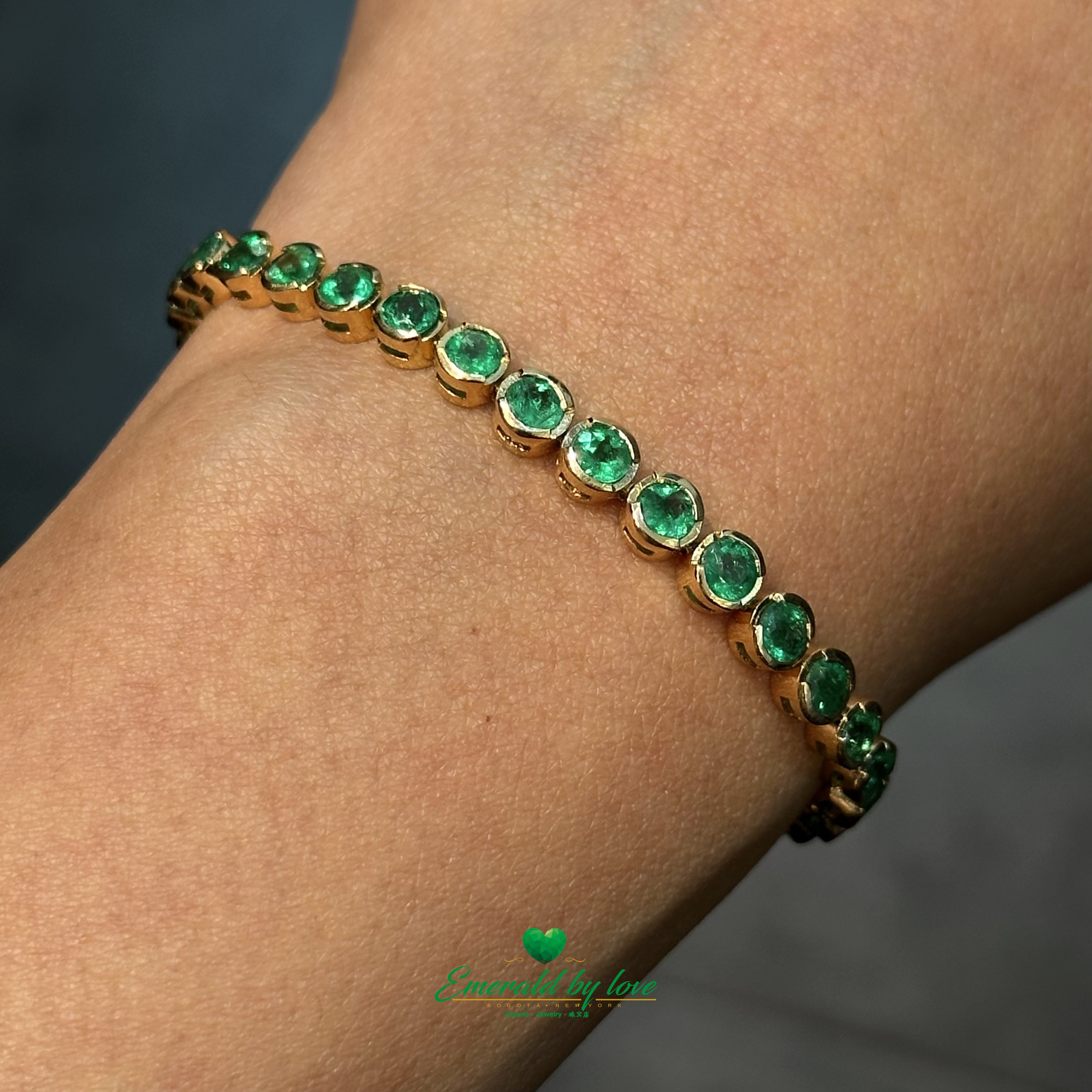Detailed view of 18K yellow gold bracelet with bezel-set emeralds