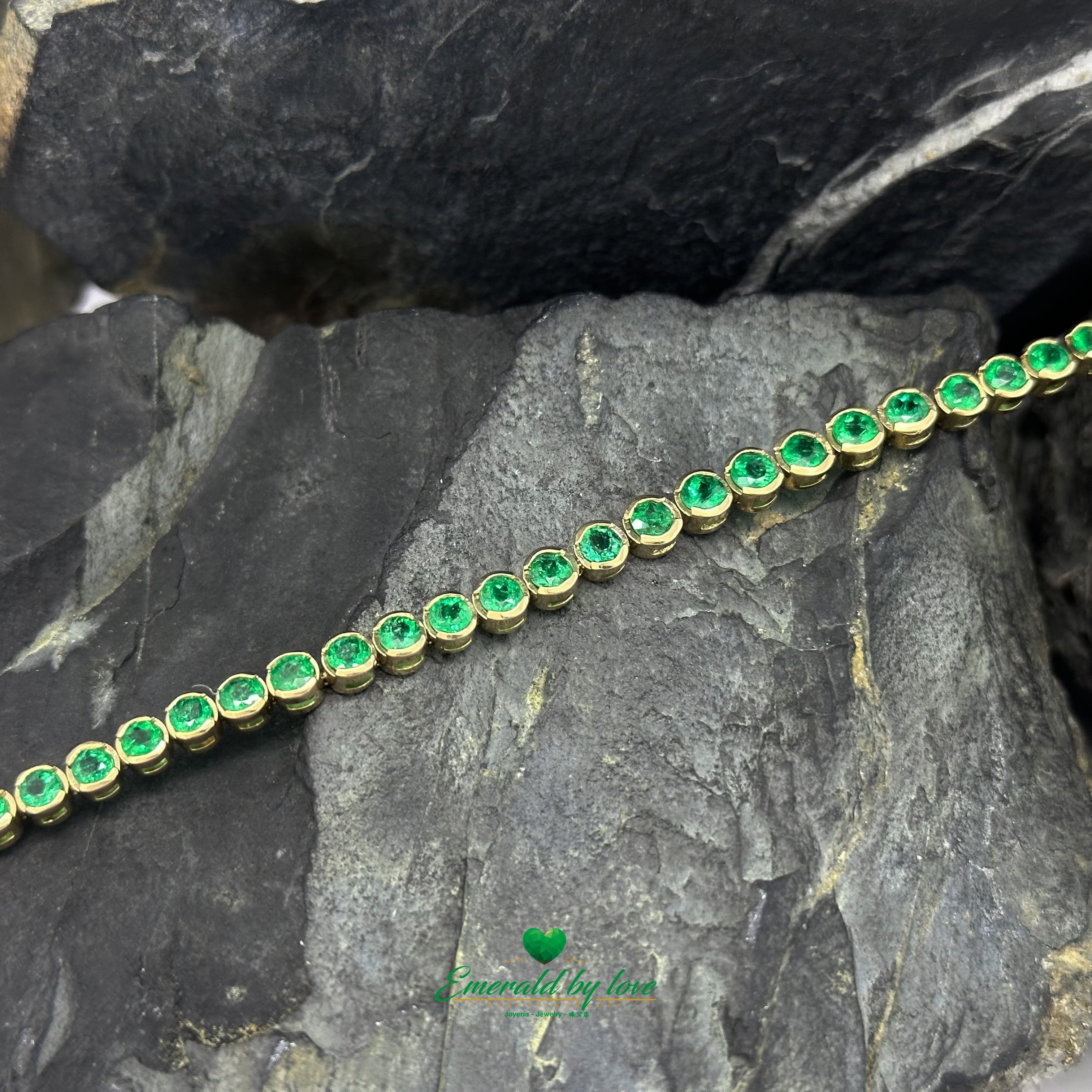 Close-up of bezel-mounted emerald bracelet in fine yellow gold