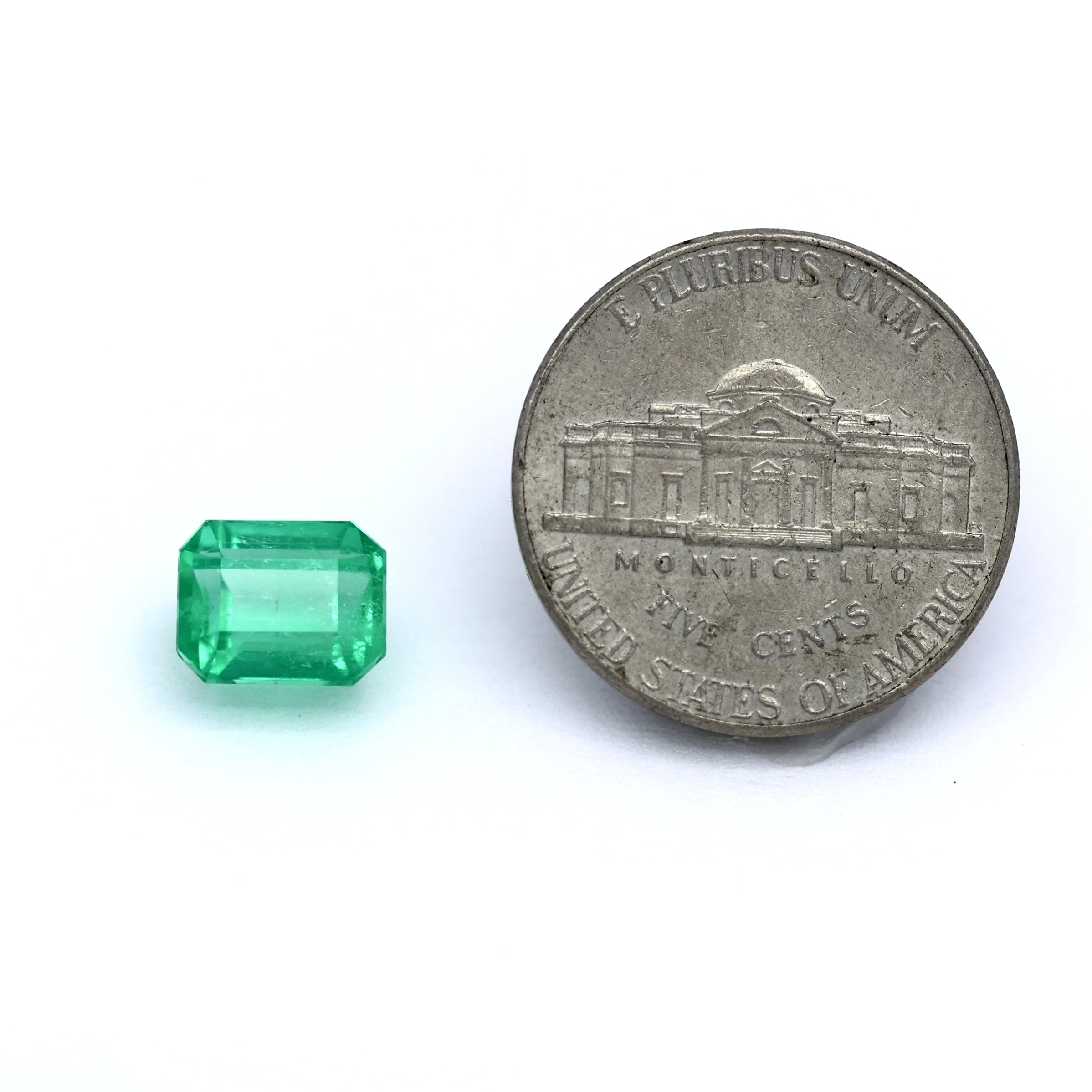 Coin comparison of size emerald cut colombian emerald 