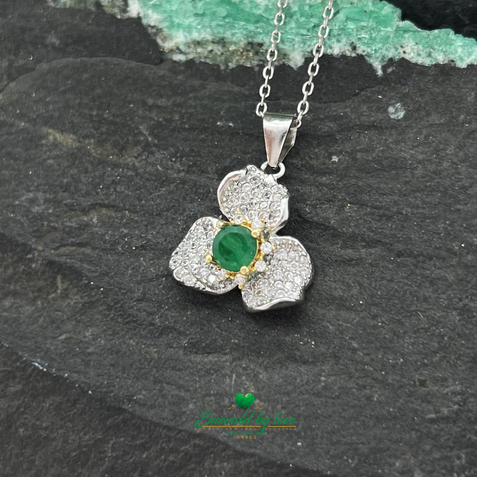 Exquisite Orchid Pendant with Central Emerald in Gold-Plated Prongs