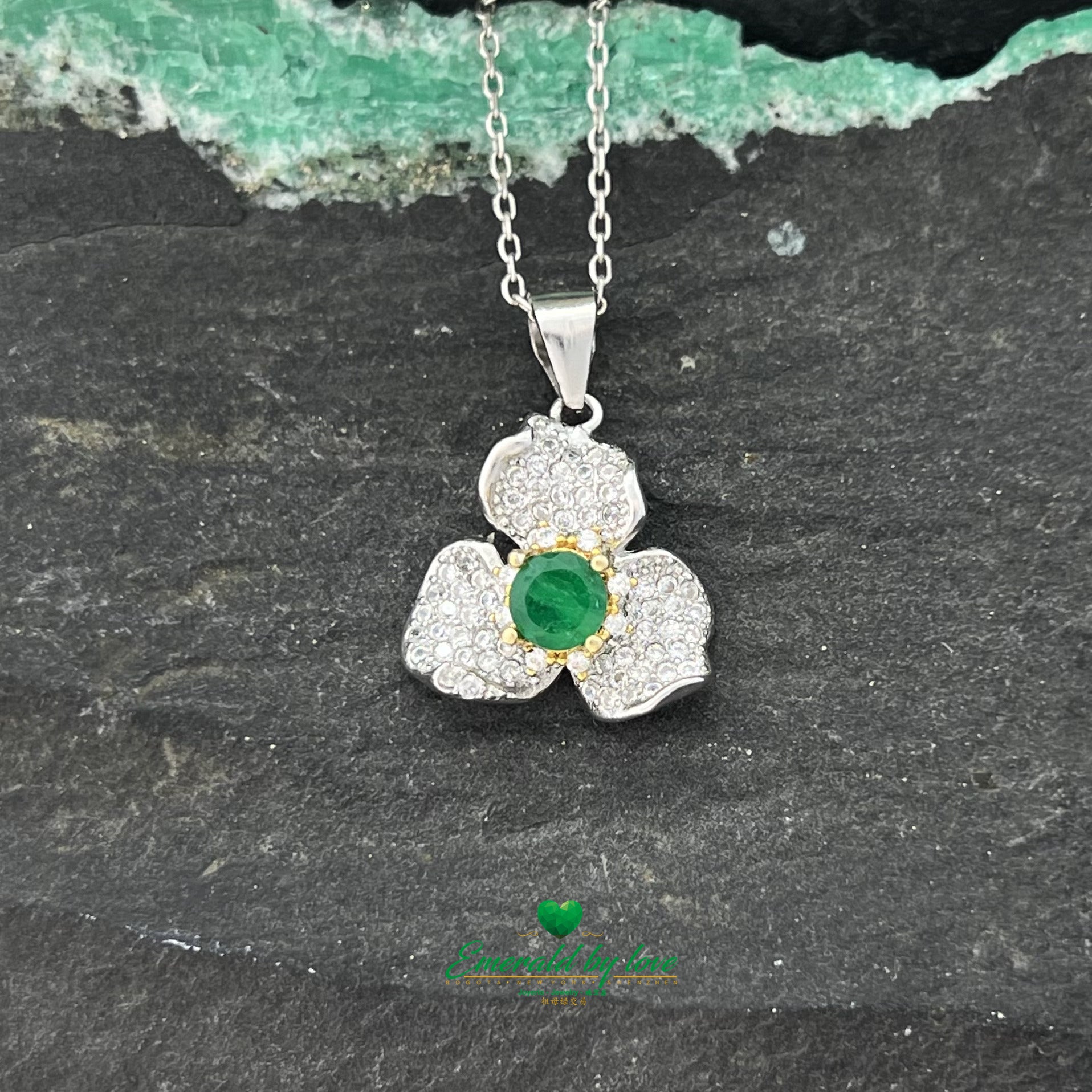 Exquisite Orchid Pendant with Central Emerald in Gold-Plated Prongs