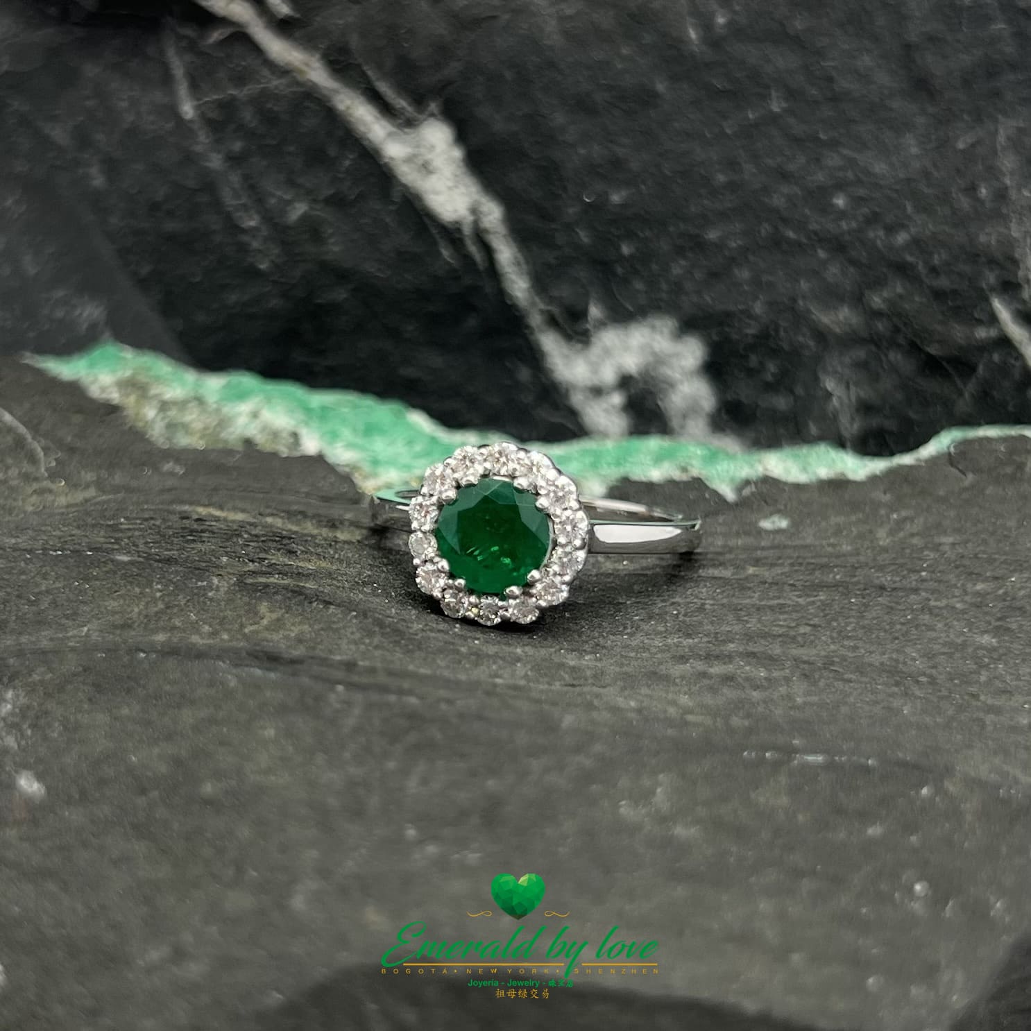 Anillo de esmeralda marquesa de oro blanco con esmeralda redonda de color verde oscuro y borde de diamantes