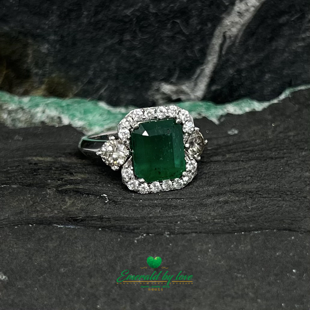 White Gold Ring with Emerald Cut Emerald Center, Flanked by Two Medium Diamonds, and Surrounded by Small Diamonds