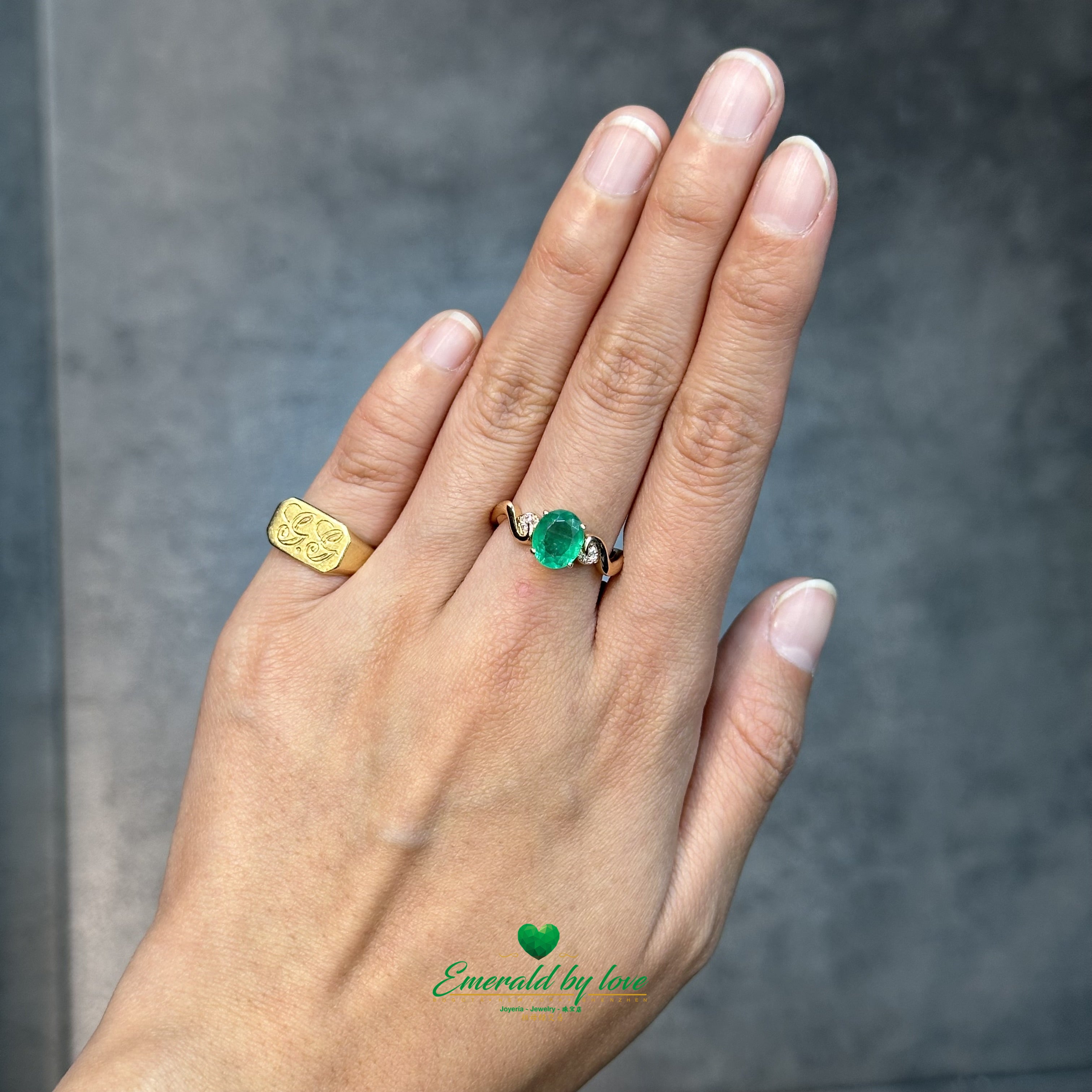 Anillo de oro rosa detallado con esmeralda ovalada central y filigrana con detalles de diamantes 