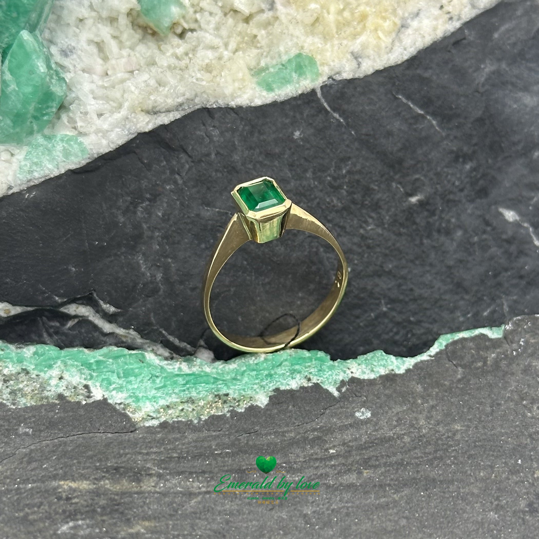 Delicado anillo de oro amarillo con esmeralda colombiana rectangular en engaste de bisel