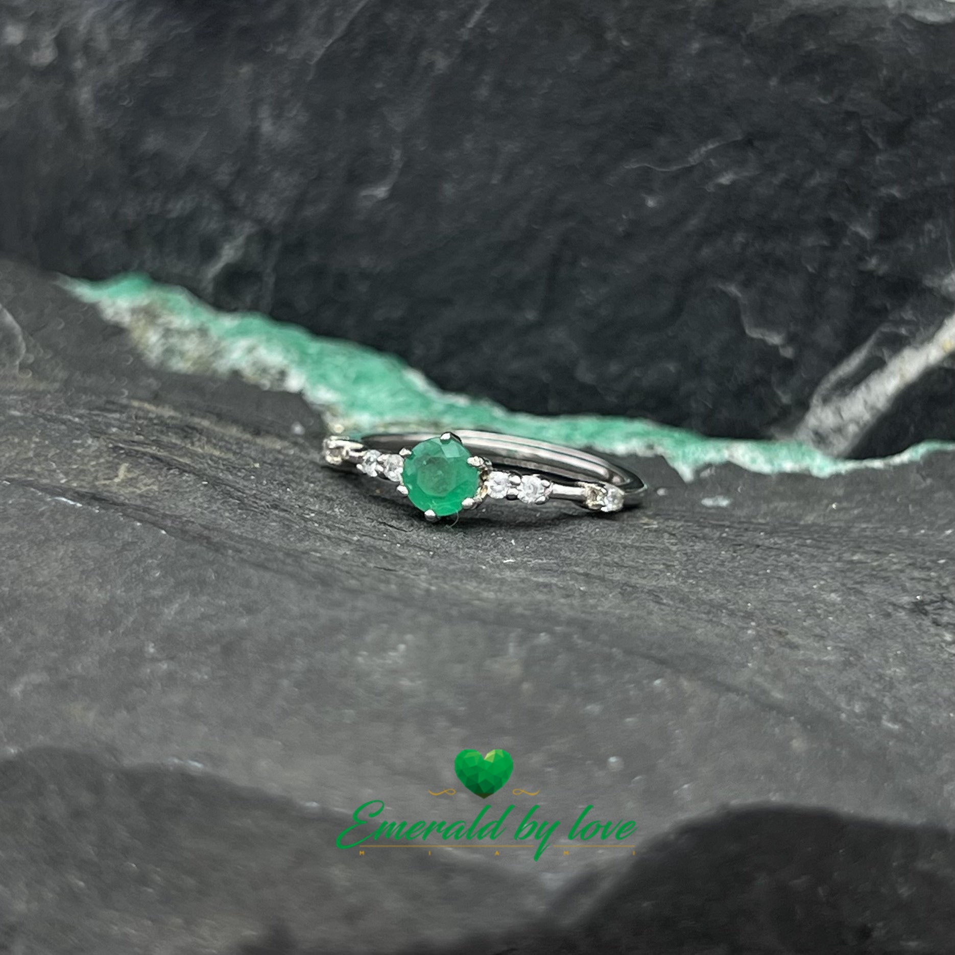 Fine Ring with Delicate Band Decorated with Zircons and Central Round Emerald