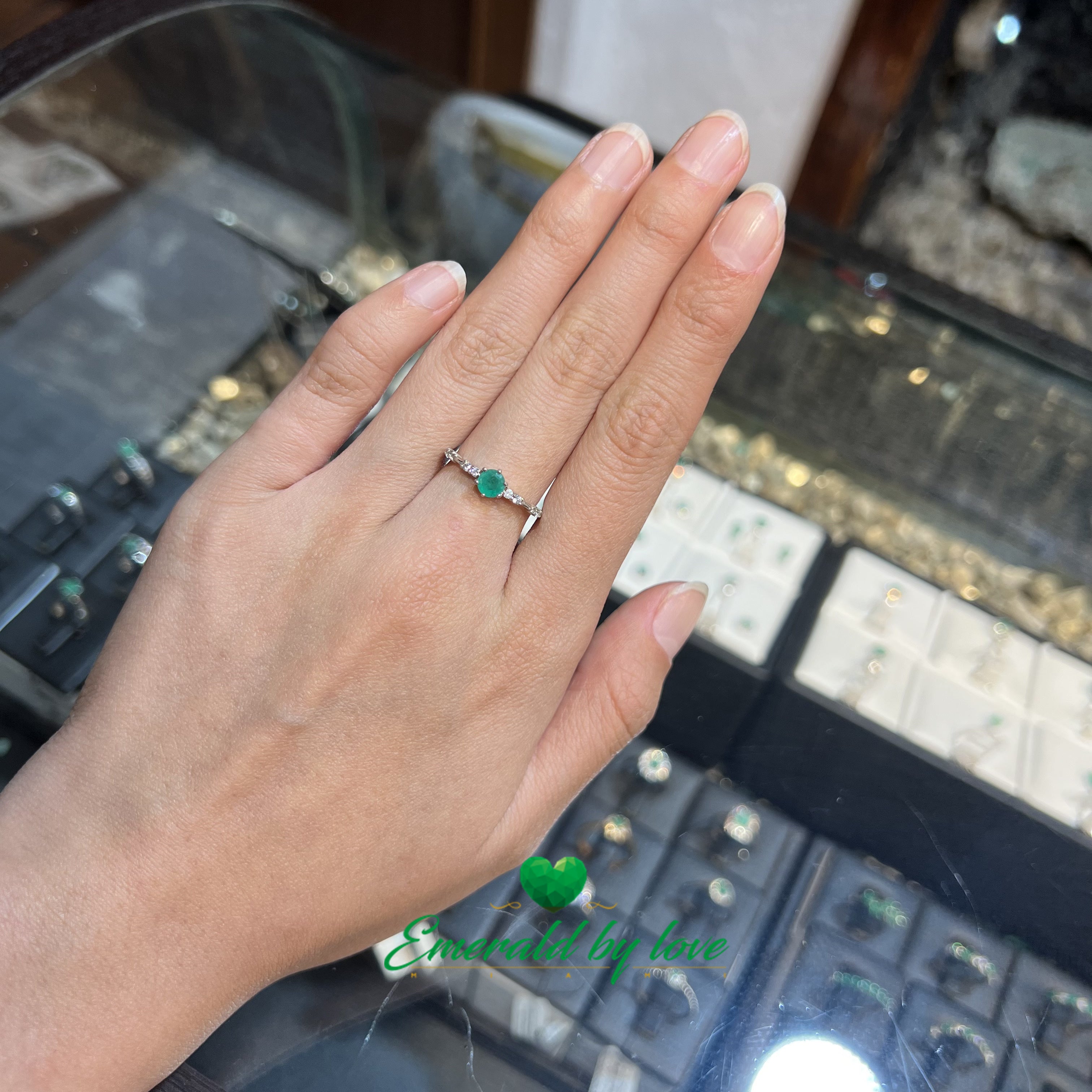 Fine Ring with Delicate Band Decorated with Zircons and Central Round Emerald